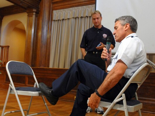 Air Force Lt. Col. Andrew Lourake, an amputee who remained on active duty as a pilot, demonstrates July 17 how he manually switches modes on his computerized prosthesis as Sven Zarling observes. The colonel's current prosthetic leg has two modes, one for walking and one for flying. An improved prosthesis is being developed that will have up to 10 modes and allow for remote-controlled switching. Mr. Zarling is from Otto Bock HealthCare, the company developing the new prosthesis.  (DOD photo/Fred W. Baker III)