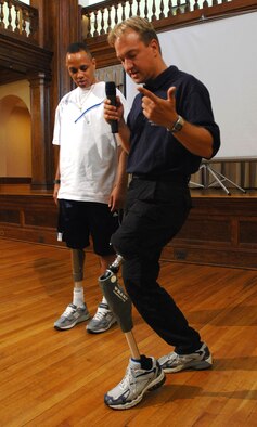 Army Spc. Charles Parker looks on as Sven Zarling demonstrates the capabilities of a prototype prosthesis July 17 designed to give above-the-knee amputee servicemembers the mobility they need to remain on active duty if they choose. The prosthesis uses a microprocessor to control the knee's hydraulic functions and can anticipate the wearer's actions and make changes in real time.  Mr. Zarling is from Otto Bock HealthCare, the company developing the new prosthesis.  (DOD photo/Fred W. Baker III)