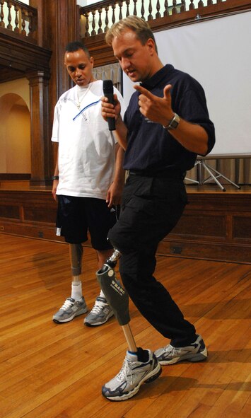Army Spc. Charles Parker looks on as Sven Zarling demonstrates the capabilities of a prototype prosthesis July 17 designed to give above-the-knee amputee servicemembers the mobility they need to remain on active duty if they choose. The prosthesis uses a microprocessor to control the knee's hydraulic functions and can anticipate the wearer's actions and make changes in real time.  Mr. Zarling is from Otto Bock HealthCare, the company developing the new prosthesis.  (DOD photo/Fred W. Baker III)