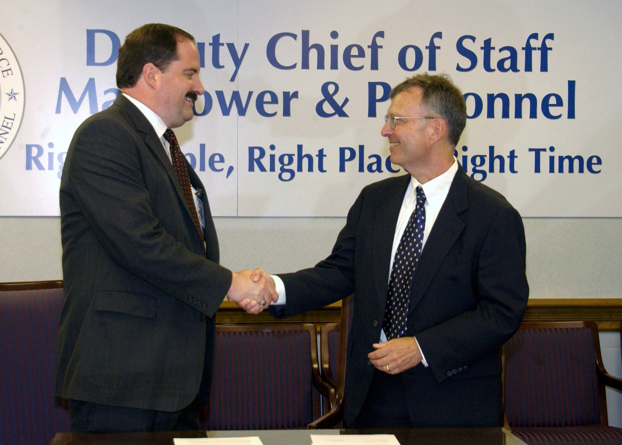 Tim Beyland (left), assistant deputy chief of staff for Air Force Manpower and Personnel, and Steven Cole, CEO of the Council of Better Business Bureaus, shake hands after signing a memorandum of understanding July 16 at the Pentagon. The memorandum establishes a partnership between the Air Force and CBBB to offer programs, services and materials to assist Air Force members and their families with a variety of consumer-related issues. (U.S. Air Force photo/Staff Sgt. Monique Randolph)
