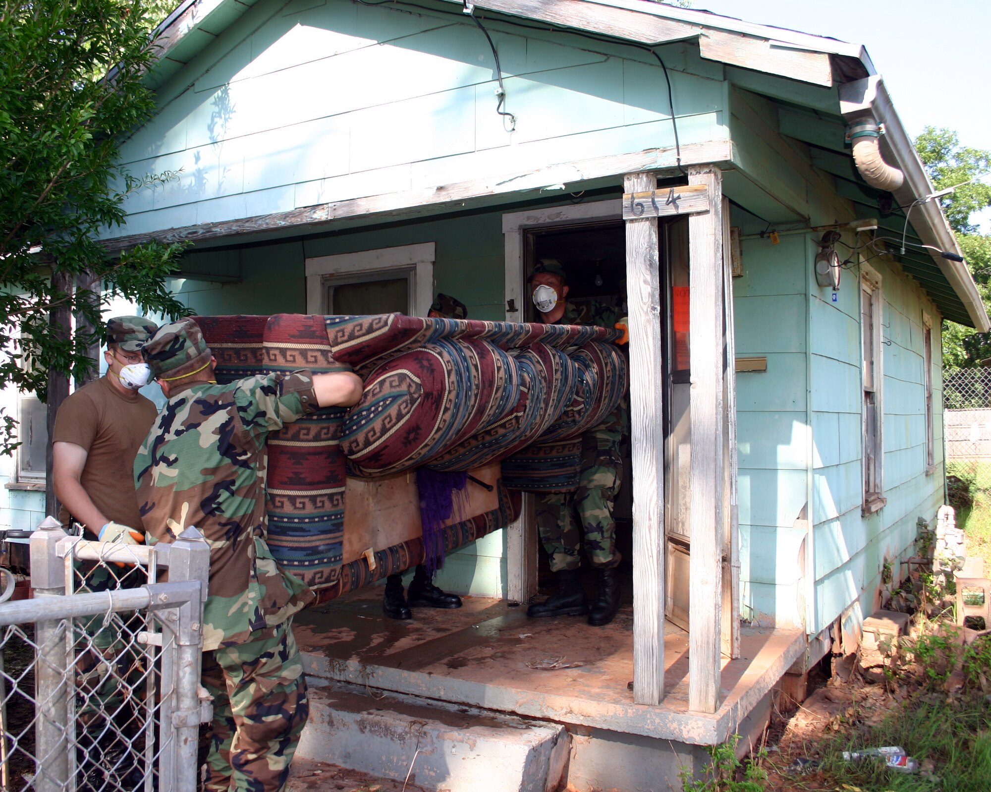 Airmen-in-Training from the 361st Training Squadron remove waterlogged furniture from a flood victim's home July 21.  The AiTs volunteered to spend their weekends working with United Way in salvage efforts across Wichita Falls. (U.S. Air Force photo/Staff Sgt. Tonnette Thompson)