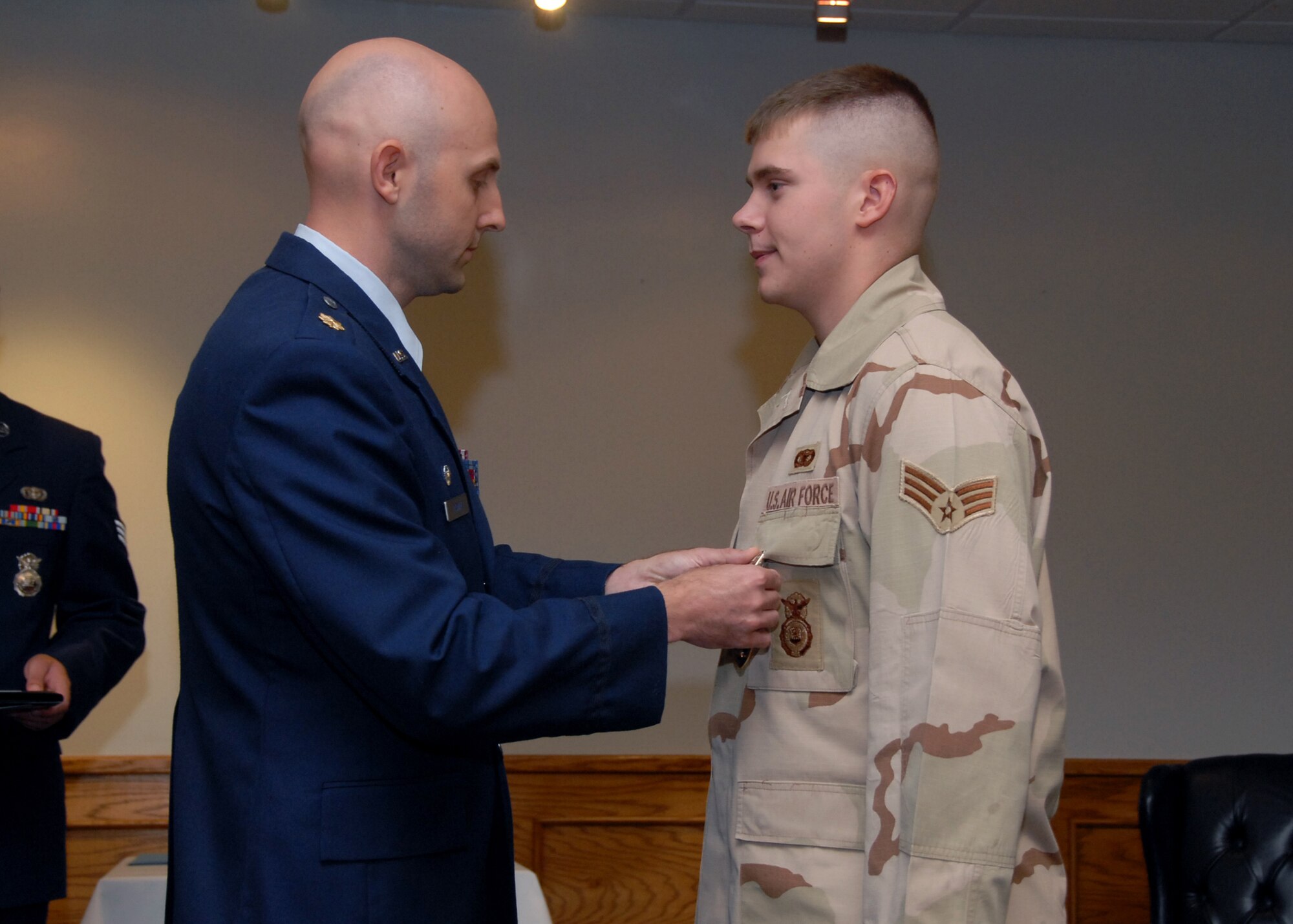Maj. Gregory Nowak, 82nd Security Forces Squadron commander, presents Senior Airman Shawn Ryan, 82nd SFS, the Purple Heart for injuries sustained while deployed to Iraq, July 16 at the Sheppard Club. (U.S. Air Force photo Mike Litteken)