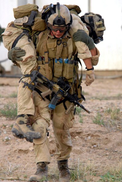 Senior Airman Dwight Funk carries a simulated survivor out of a house during a training scenario July 13 at Playas, N.M., that is part of Exercise Angel Thunder 2007.  Angel Thunder is a combat search and rescue task force exercise designed to test theater spin-up capabilities and examine the integration of all Air Force assets in mission planning procedures and mission execution.  Airman Funk is a pararescueman from the 58th Rescue Squadron at Nellis Air Force Base, Nev.  (U.S. Air Force photo/Senior Airman Christina D. Ponte)