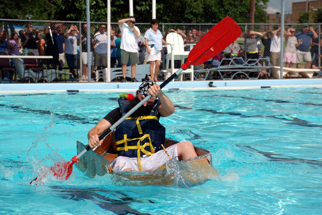 Airman Matthew Turco, an Airman-in-Training with the 360th Training Squadron and member of the Nasty Pirates boat race team, paddles furiously during the annual Build-a-Boat Race July 14 at the main pool. (U.S. Air Force photo/Airman 1st Class Jacob Corbin)