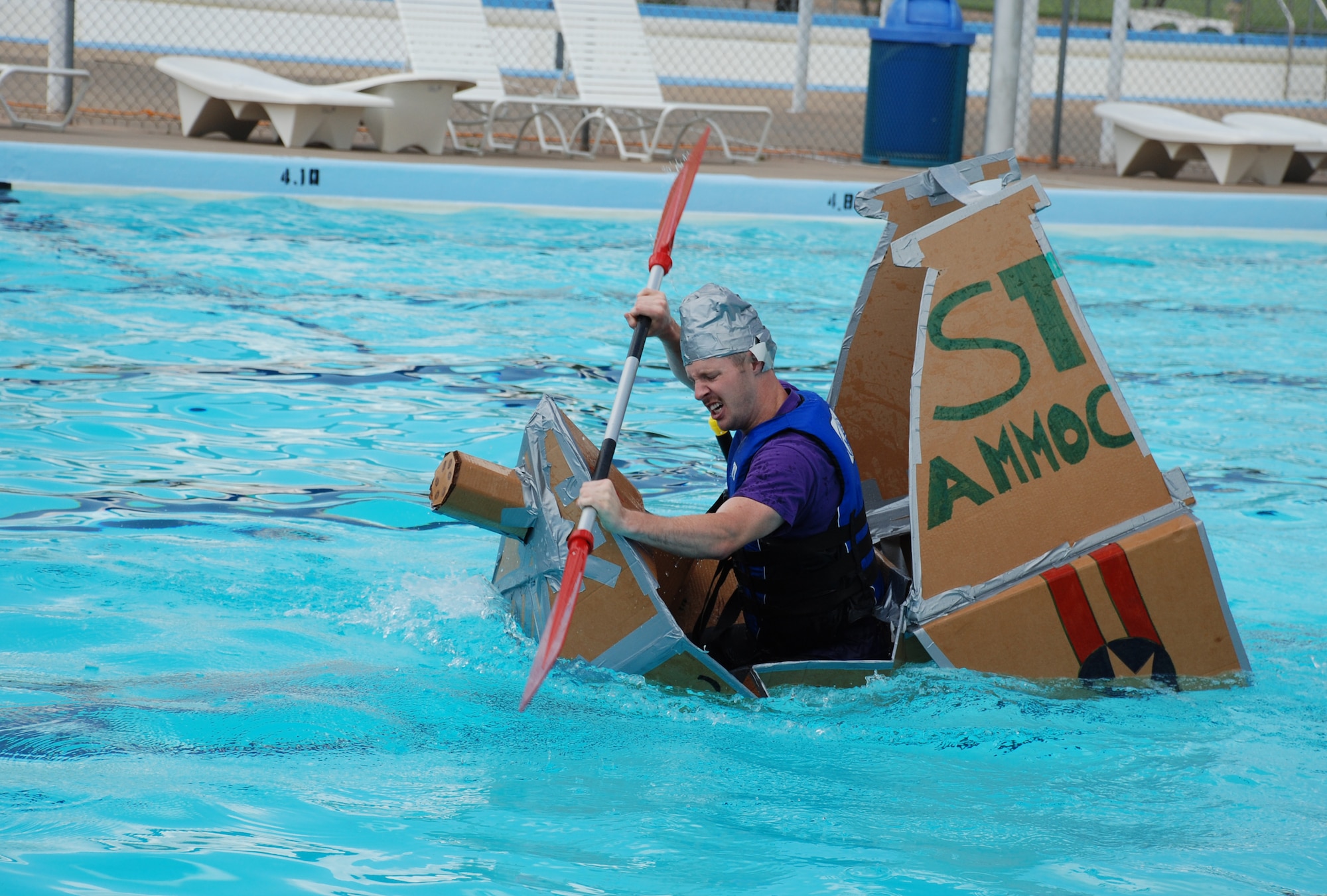2nd Lt. Jeffery Fry, 360th Training Squadron aircraft maitenance officers course student, fights to keep his vessel afloat during the annual Build-a-Boat Race July 14 at the main pool. (U.S. Air Force photo/Airman 1st Class Jacob Corbin)