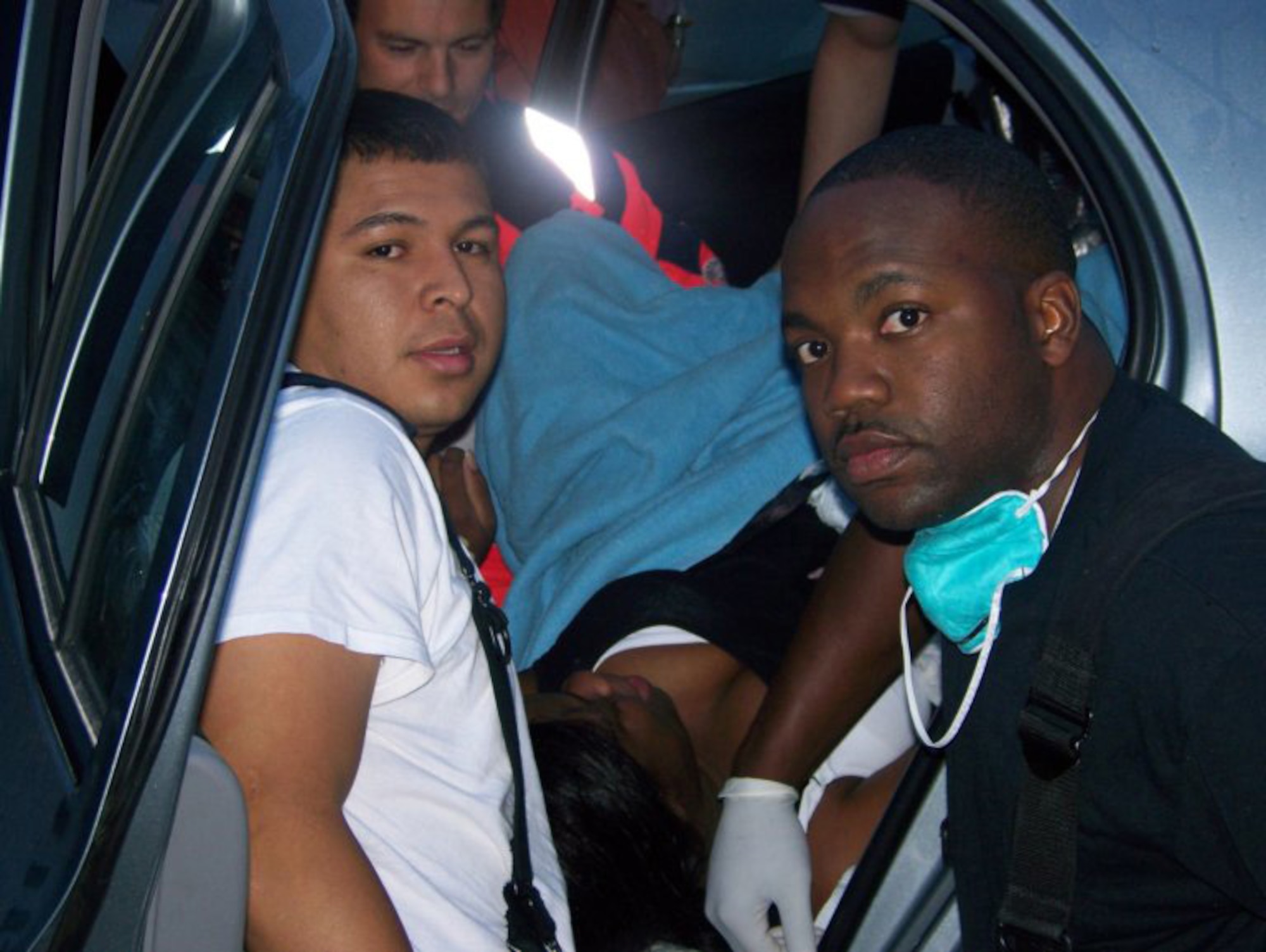 Staff Sgt. Juan Rodriquez, left, and Staff Sgt. Therman Watkins, both rescue technicians with the 435th Civil Engineer Squadron, help Senior Airman Kenyata Jenkins into the backseat of her car at the West Gate July 1 and prepare her for delivery. Airman Jenkins gave birth to her second daughter, Jordan Christina.