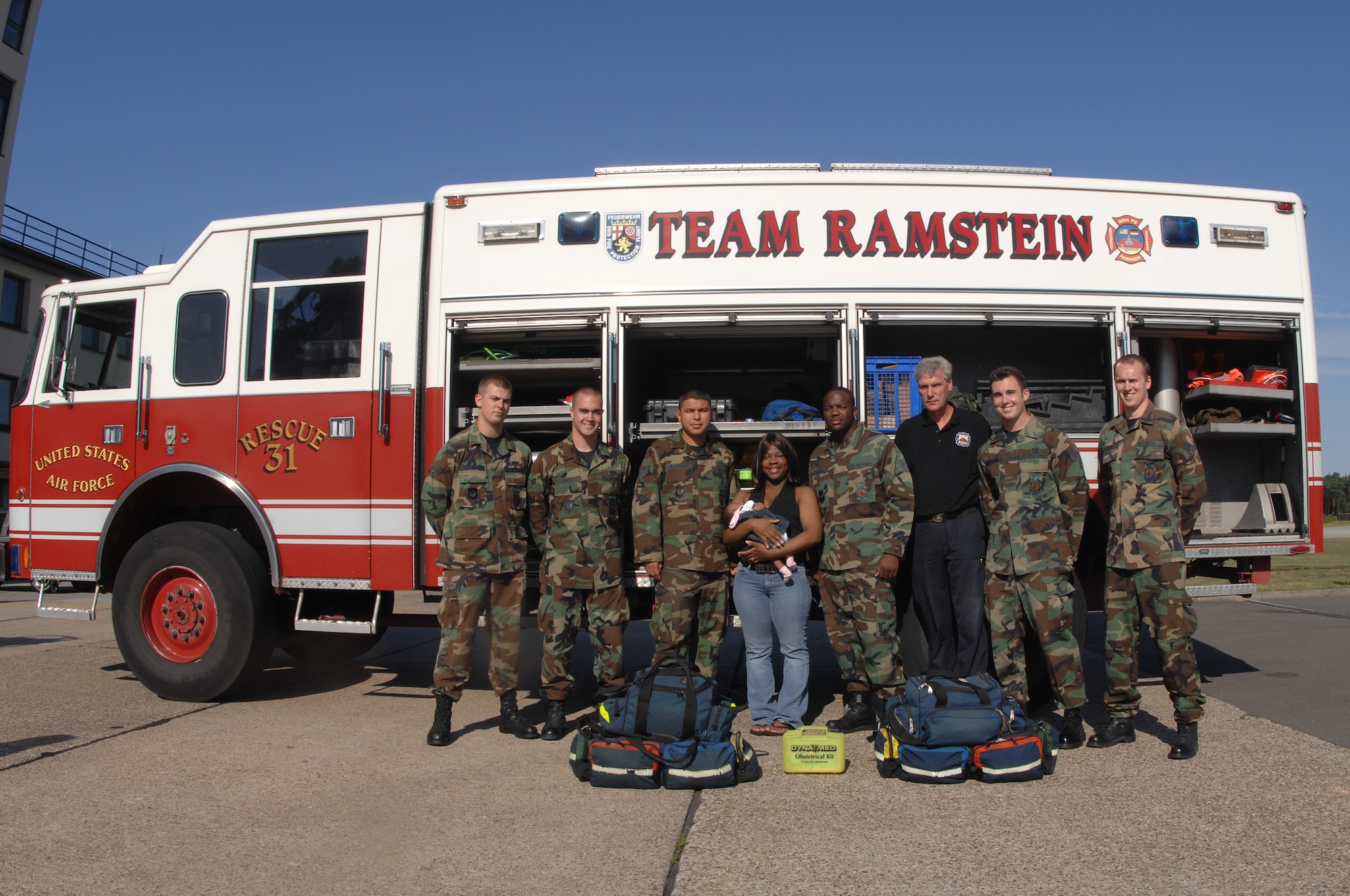 Senior Airman Kenyata Jenkins and her new born baby, Jordan Dixon (middle) stand with the 435th Civil Engineer firefighters July 16, 2007 at Ramstein Air Base Germany. The 435th Firefighters delivered Airman Jenkins' baby at the Ramstein Air Base West Gate July 1, 2007 when Airman Jenkins' labor progressed too quickly for her to travel to Landstuhl Regional Medical Center. (U.S. Air Force photo/Airman 1st Class Kenny Holston)