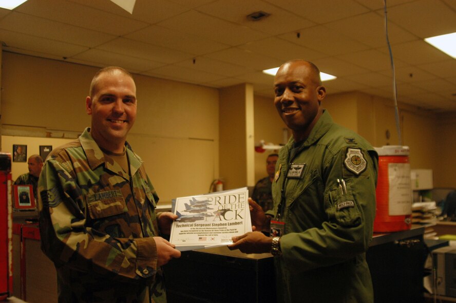 KUNSAN AIR BASE, Republic of Korea -- Tech. Sgt. Stephen Lambert, 8th Aircraft Maintenance Squadron, assistant support section chief, received a suprise visit from Col. CQ "Wolf" Brown, 8th Fighter Wing commander Wednesday. Sergeant Lambert was recognized as the 8th FW Pride of the Pack. (U.S. Air Force photo/Master Sgt. Sean Houlihan)                               