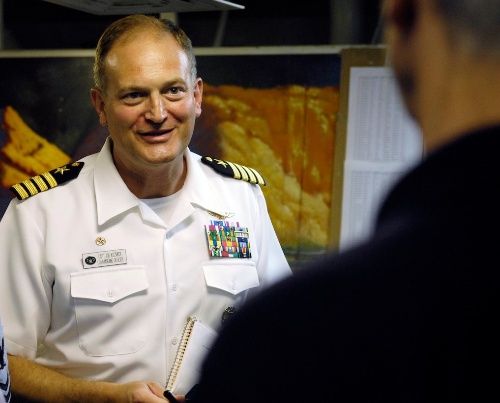 U.S. Navy Capt. Joe Kuzmick, commanding officer for the USS Mount Whitney, speaks with Deputy Defense Secretary Gordon R. England during a visit to the ship, July 18, 2007.