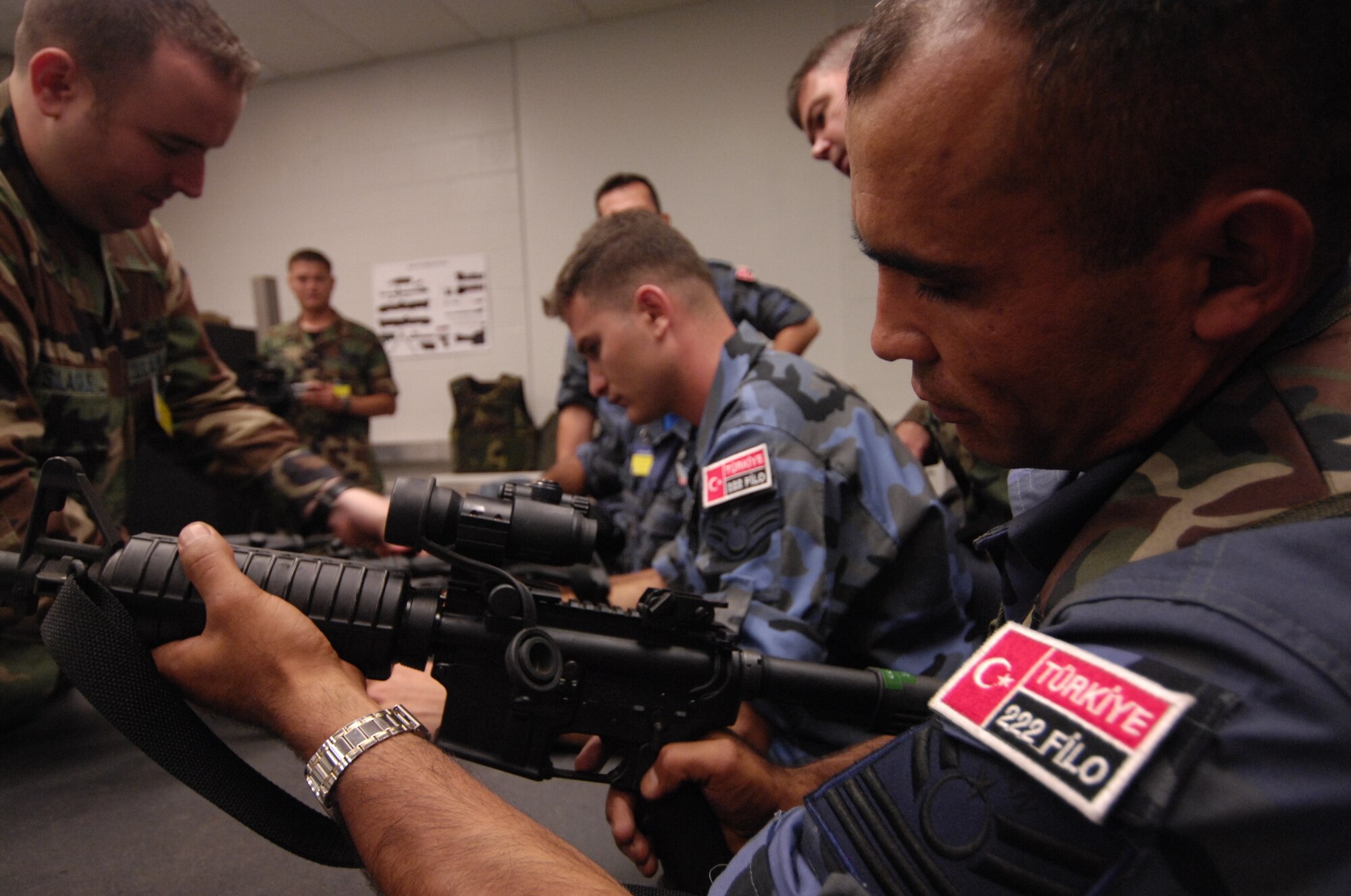 Airman Togusoglu Mustafa with the Turkish Air Force inspects a M-4 Carbine July 17 while receiving a weapons briefing prior to Rodeo competition from Tech. Sgt Robert Kampart, a combat arms instructor from McChord Air Force Base, Wash. Air Mobility Rodeo 2007, hosted by Air Mobility Command, is a readiness competition of U.S. and international mobility air forces. It focuses on improving warfighting capabilities and support of the Global War on Terrorism. (USAF Photo by Tech. Sgt. John M. Foster)