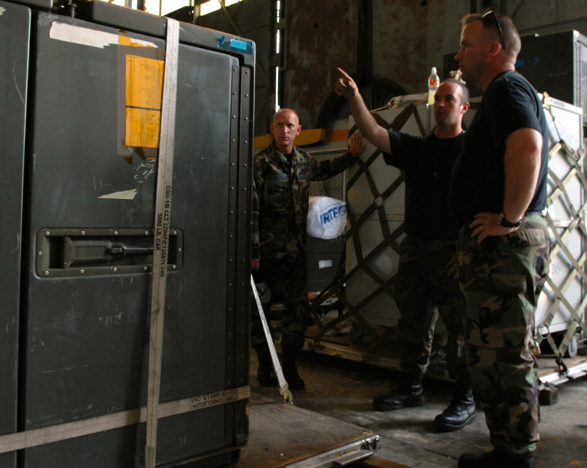 WHITEMAN AIR FORCE BASE, Mo. -- Staff Sgt. David Gott, 509th Maintenance Squadron, (center) asks Tech. Sgt. Jeffrey Mount, 509th Logistics Readiness Squadron, about a possible discrepancy in the way the hazardous airlift material is harnessed as Chief Master Sgt. Brian Hornback, 509th Bomb Wing command chief master sergeant, takes note of the cargo training July 18. More than 12 squadrons took part in the training designed to properly prepare cargo for deployment. (U.S. Air Force photo/Airman 1st Class Stephen Linch)