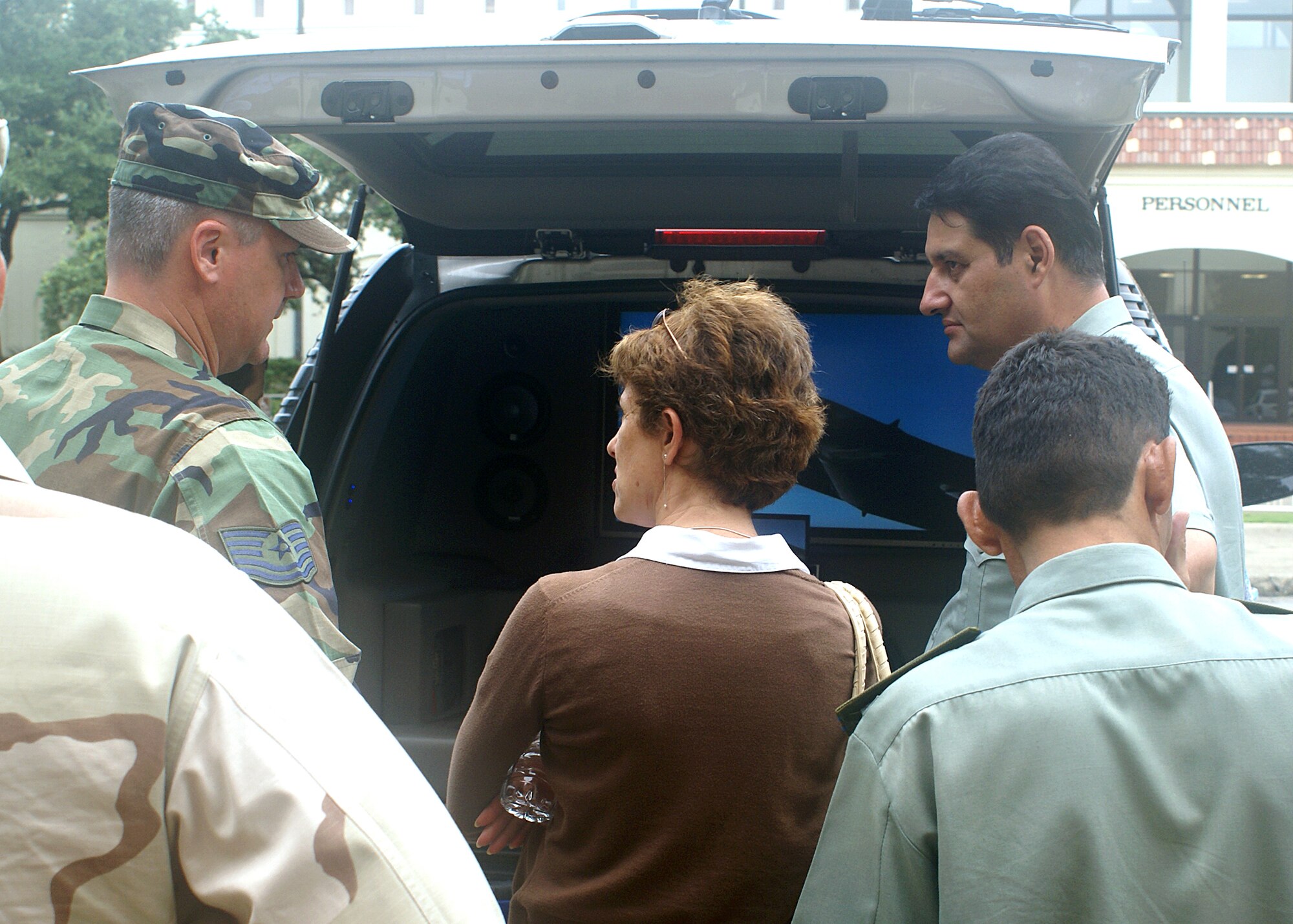 Air Force Event Marketing Recruiter, Tech Sgt. Larry B. Wright, goes over the multimedia tools incorporated on an Air Force Raptor utility vehicle with State Department interpretor, Elena Goldis, and General Major Akbarjon Kyumov of the Tajikistan military.  The Tajik delegation visited Recruiting Service to explore techniques that could help generate interest in joining their military. (Air Force photo/Chet DelSignore)