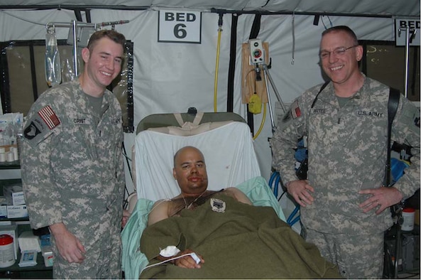 LSA ANACONDA, Iraq -- Chief Warrant Officer 2 Allen Crist (left) and Chief Warrant Officer 4 Kevin Purtee, check on the medical condition of Spc. Jeffrey Jamaleldine following a harrowing mission to evacuate the wounded Soldier. (U.S. Army photo/Maj. Gregory O’Connor)