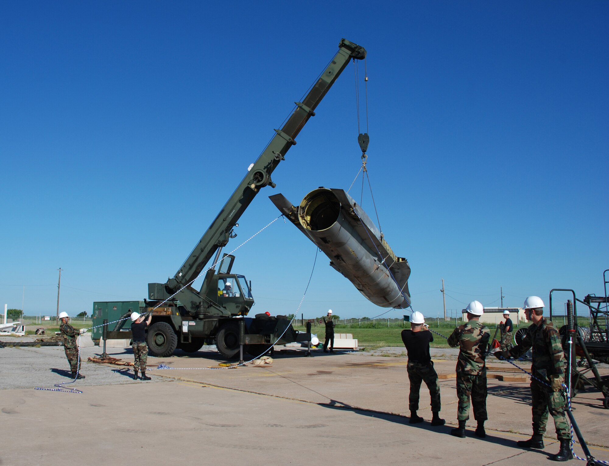 Members of the 27th Equipment Maintenance Squadron from Cannon Air Force Base, New Mexico, work together to hold the fuselage of an F-16 Fight Falcon still before loading it onto a trailer bed July 19 at Sheppard AFB. The F-16 is destined to become a static display at Cannon in honor of the 27th Fighter Wing, which is deactivating. (U.S. Air Force photo/Airman 1st Class Jacob Corbin)
