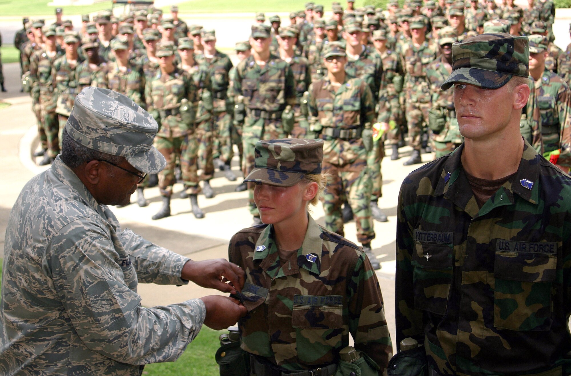 Brig. Gen. Alfred Flowers, Air Force Officer Accessions and Training commander, pins the Prop and Wings pin on Cadet Group Commander Jefre Potterbaum (right) and Deputy Group Commander Ashley Currie July 17 at the conclusion of the Prop and Wings Challenge at Maxwell Air Force Base, Ala. The challenge tested more than 330 cadets with mental and physical activities during the 27-day field training event. (U.S. Air Force photo/Staff Sgt. Jason Lake)