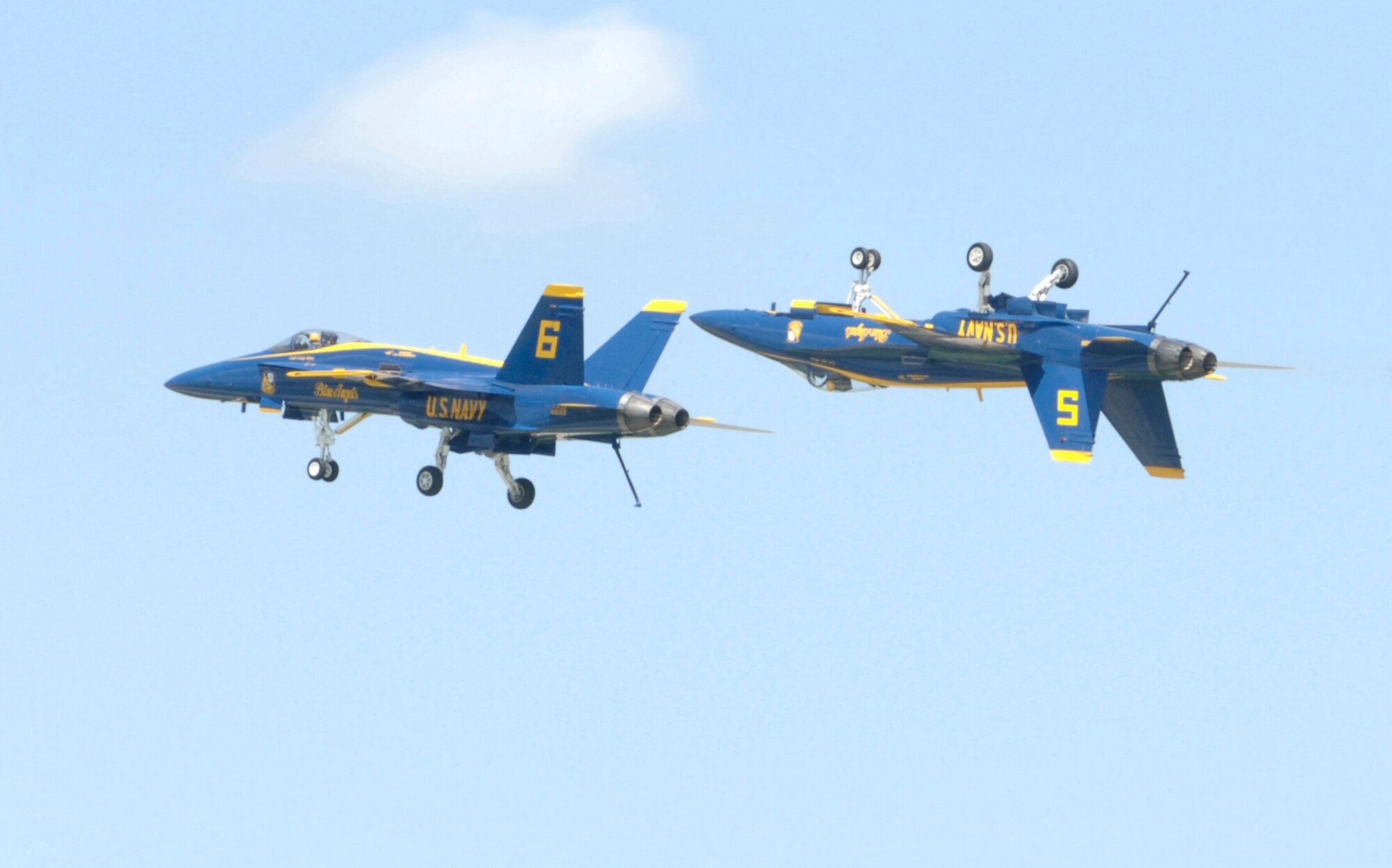 MCCONNELL AIR FORCE BASE, Kan. -- Two F/A-18 Hornets from Navy Blue Angels aerial demonstration team perform an aerial maneuver while at close-range July 14 at McConnell’s Open House. One F/A 18 flew right-side up while the other flew just behind it and upside down. Approximately 101,891 people attended this year’s Open House event, which took place at McConnell July 14-15. (Photo by Airman Justin Shelton) 