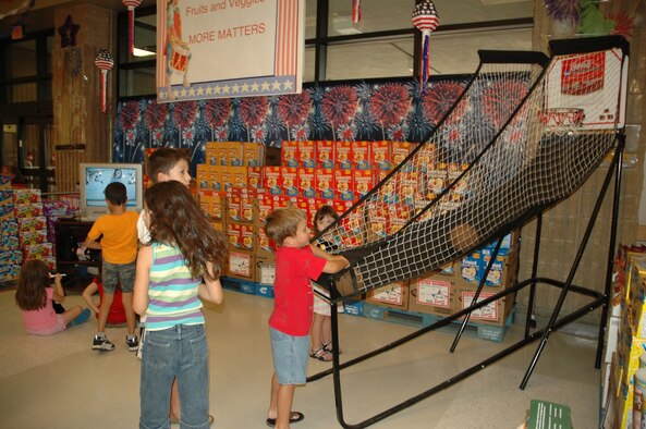 Children of deployed D-M Airmen play together at the commissary here July 15 during the "Shopping Extravaganza" organized by the 355th Mission Support Group, the Airmen and Family Readiness Center here, and the commissary staff. The event, which was part of the  D-M Community Cares program, attracted more than 500 spouses and children and featured discounted food, prize giveaways and a play area where children could be supervised while their parents shopped. (U.S. Air Force photo/Airman 1st Class Jamie Coggan)