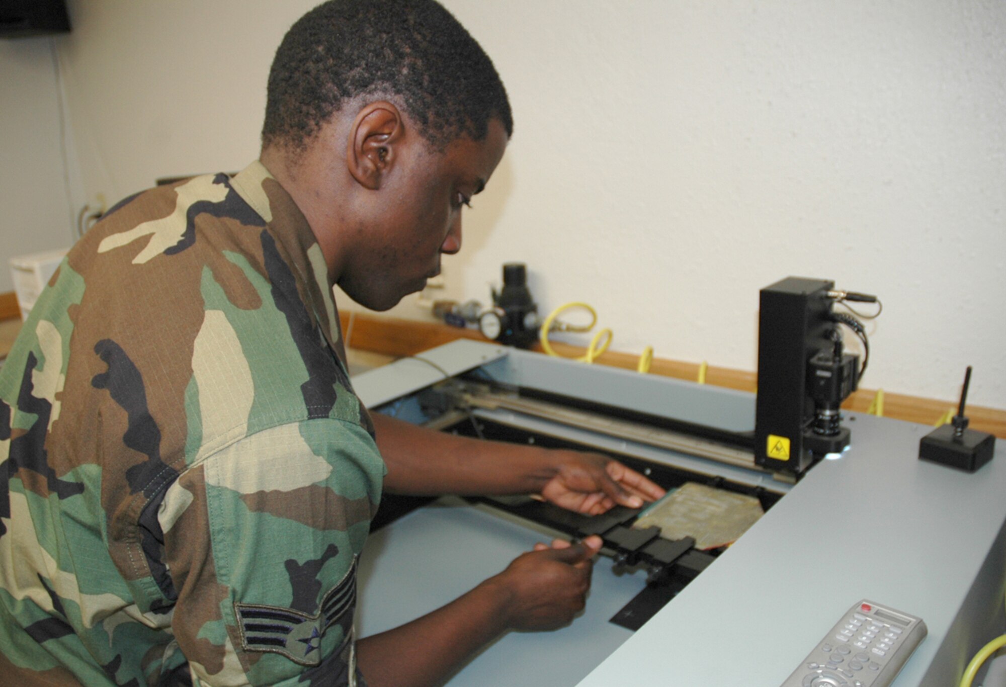 Senior Airman Torry Murray, an AFREP technician here, aligns a malfunctioning circuit card assembly into a troubleshooting card reader. Using a database that includes specifications for various circuit cards in use throughout the military, the machine runs diagnostic tests and reveals the cards’ problems to the maintainers. (U.S. Air Force photo/Staff Sgt. Jake Richmond)