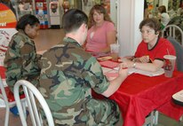 FAIRCHILD AIR FORCE BASE, Wash. -- Jennifer Kreuziger, Inland Northwest Blood Center recruitment coordinator, and Susan Marcus, blood drive volunteer, help sign in Airmen looking to donate blood during the INBC’s blood drive at the Base Exchange July 18. The INBC brings their mobile blood –donating unit on base three times a year to provide base members an opportunity to donate blood. “There are always a lot of first-time donors who are either new to the area or have just never donating. We really appreciate these people taking that first step, as well as those who donate regularly,” said Ms. Kreuziger. “It’s always a success when we come to Fairchild.”
