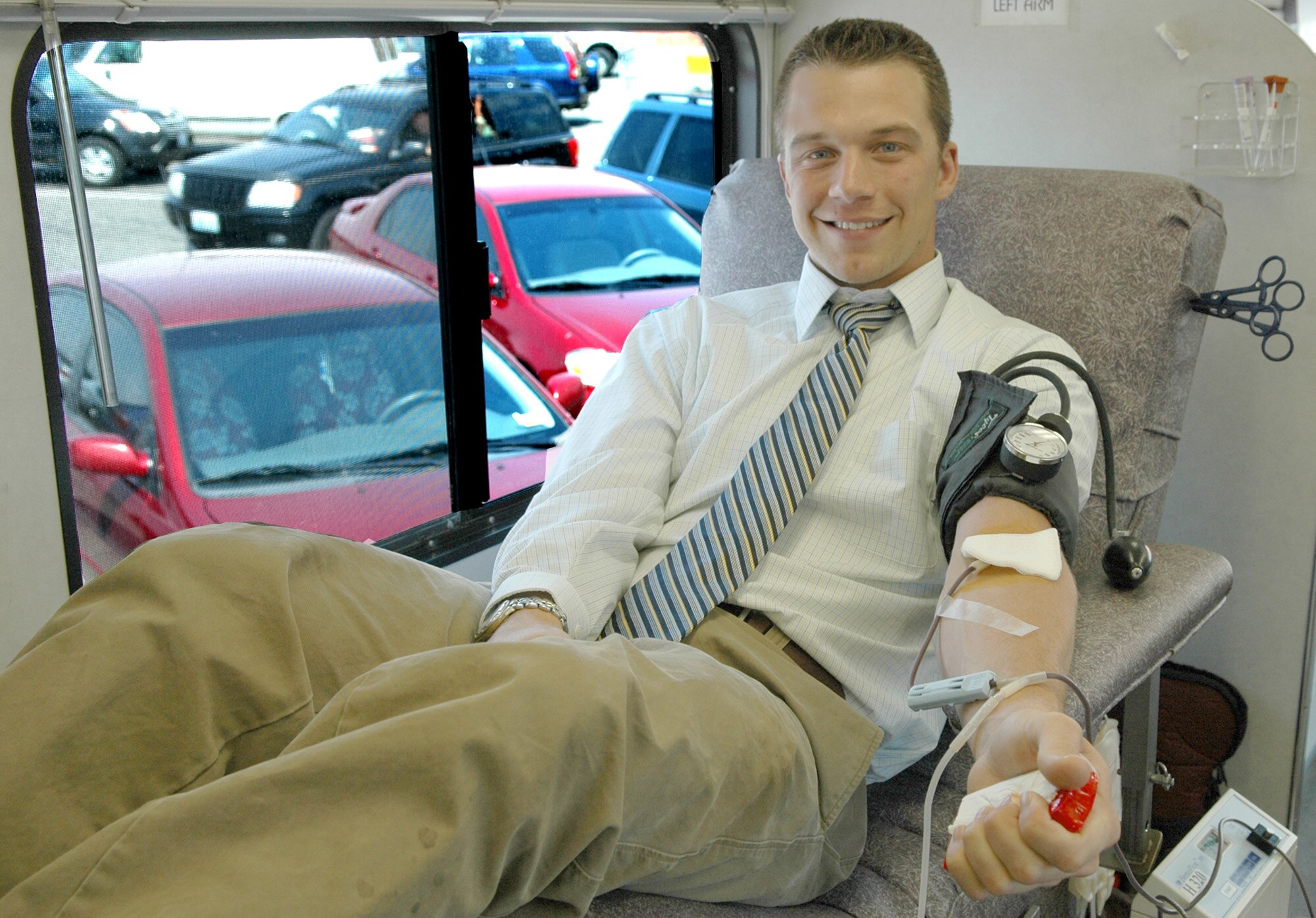 FAIRCHILD AIR FORCE BASE, Wash. -- Kurt Mabis, a legal intern at the 92nd Air Refueling Wing legal office, donates blood on the Inland Northwest Blood Center bus located in the Base Exchange parking lot. Mr. Mabis has been donating for approximately nine years. “I donate because my brother needed surgery and he used someone else’s donated blood. So, I think of it as paying those people back.” Donors received a free T-shirt for their donation. (U.S. Air Force photo / Airman 1st Class Kali L. Gradishar)