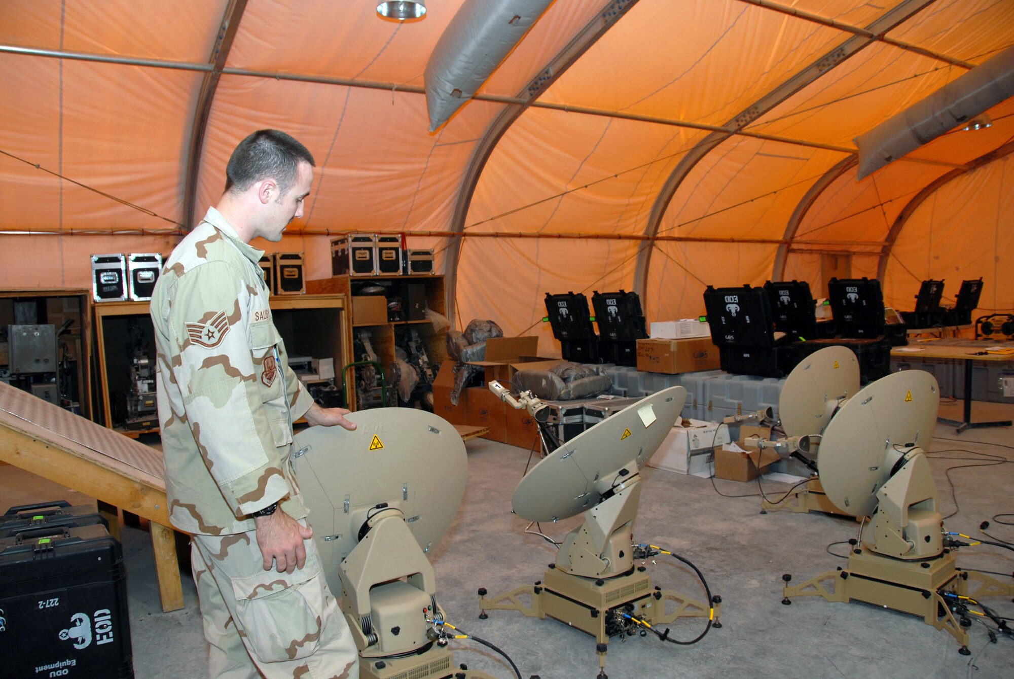 Staff Sgt. Jonathan Salisbury inspects very small aperture terminal satellite dishes that will be sent to forward-deployed explosive ordnance disposal teams in the area of responsibility July 11 in Southwest Asia. Sergeant Salisbury is assigned to the 379th Expeditionary Civil Engineer Squadron EOD unit. (U.S. Air Force photo/Airman 1st Class Ashley Tyler) 

