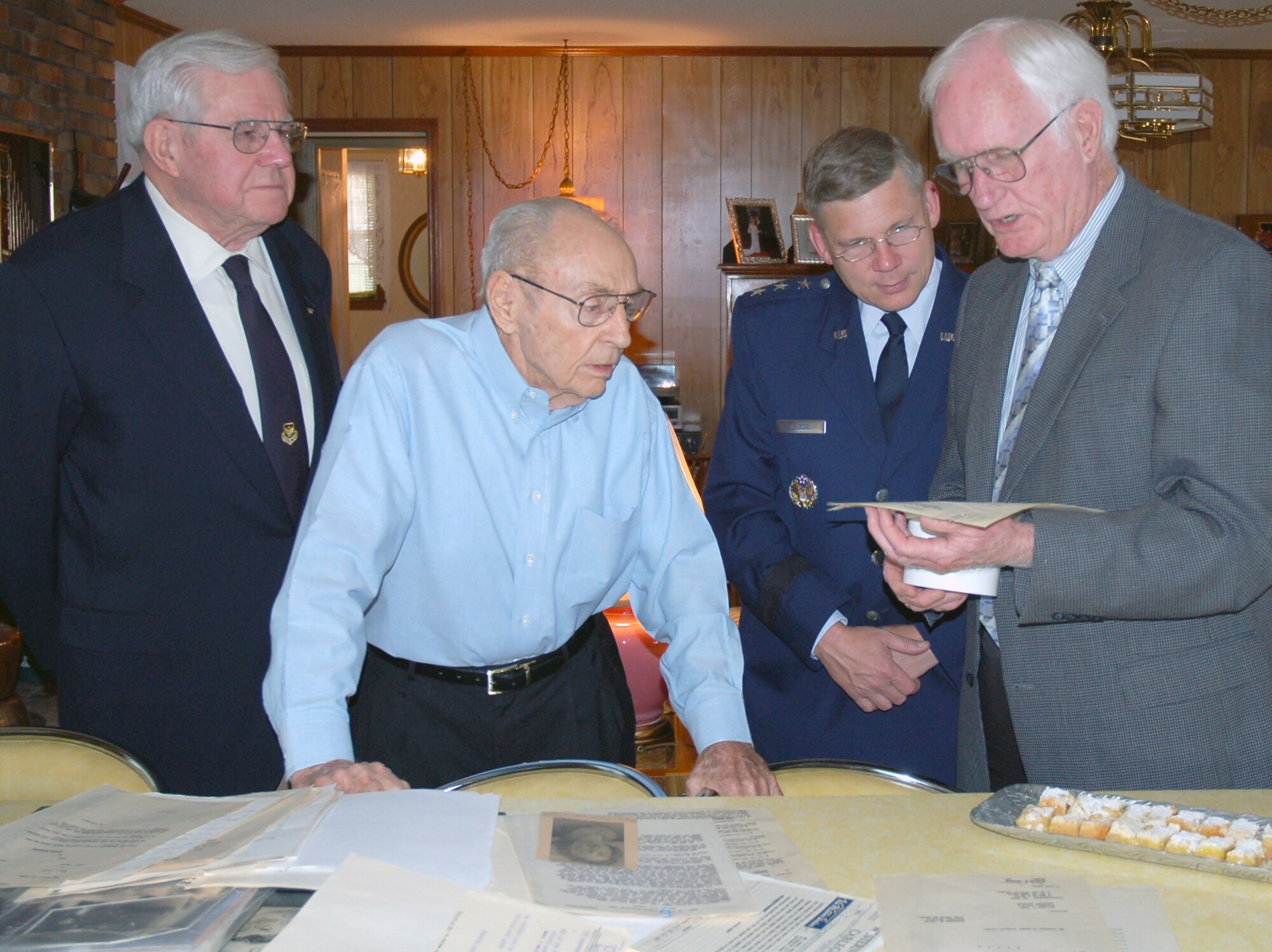 Lt. Gen. Robert J. Elder Jr., Eighth Air Force commander and two former Eighth Air Force commanders, Lt. Gen. (ret.) E.G. "Buck" Shuler Jr. and Lt. Gen. (ret.) Edgar S. Harris Jr. examine some of the mementoes of the World War II service of Lt. Col. (ret.) Charles Jones Sr., with Mr. Charles Jones Jr., who also served during World War II. Col. Jones was one of the original members of the famous Castle Coombe Mess, established by Gen. Ira C. Eaker, who first commanded Eighth Air Force in England during World War II.  General Eaker purchased the bowl and cups with the optimistic vision of conducting post-war reunions with the members of the Mess. Postwar reunions of General Eaker’s closest wartime teammates grew to be around 50 officers, collectively known as the Castle Coombe Group, which included another famous World War II leader, General Carl “Tooey” Spaatz. General Eaker donated the bowl, ladle, and his cup to Eighth Air Force, which was accepted by General Harris, as Eighth Air Force commander, on April, 28 1981. The Eaker Bowl is a physical piece of the Mighty Eighth’s history which occupies a place of honor at Eighth Air Force headquarters as a heraldic symbol of sterling service to the nation, comradeship, and optimism about the future by those who have served with The Mighty Eighth. (U.S. Air Force Photo by Capt. Rob Goza)