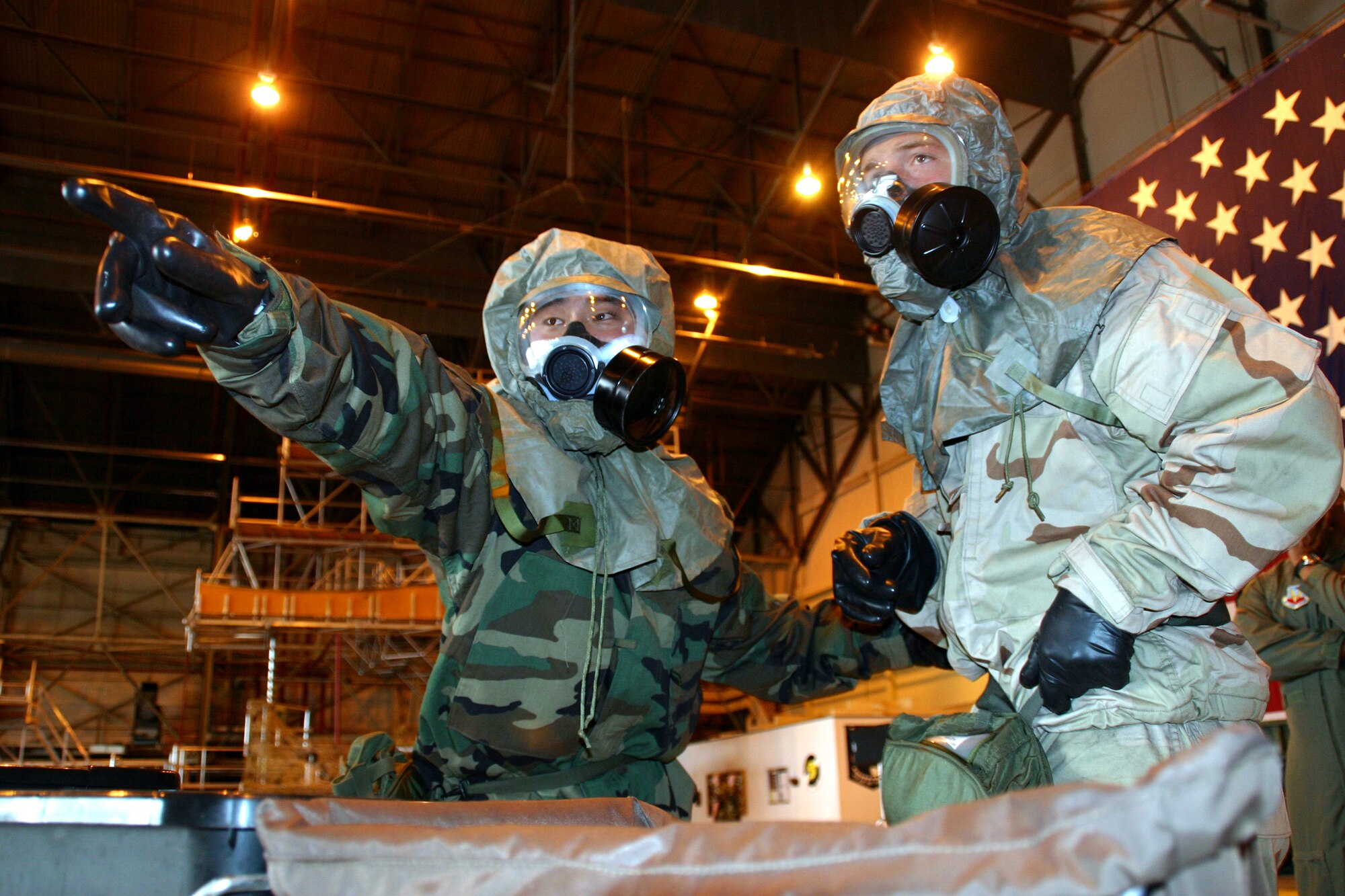 Airman 1st Class Chris Reyburn and Airman Christian Sousa, 552nd Air Maintenance Squadron, ensure they perform all required tasks while going through a chemical decontamination line during the ATSO (Ability to Survive and Operate) Rodeo challenge July 13. (Photo by Senior Airman Lorraine Amaro)
