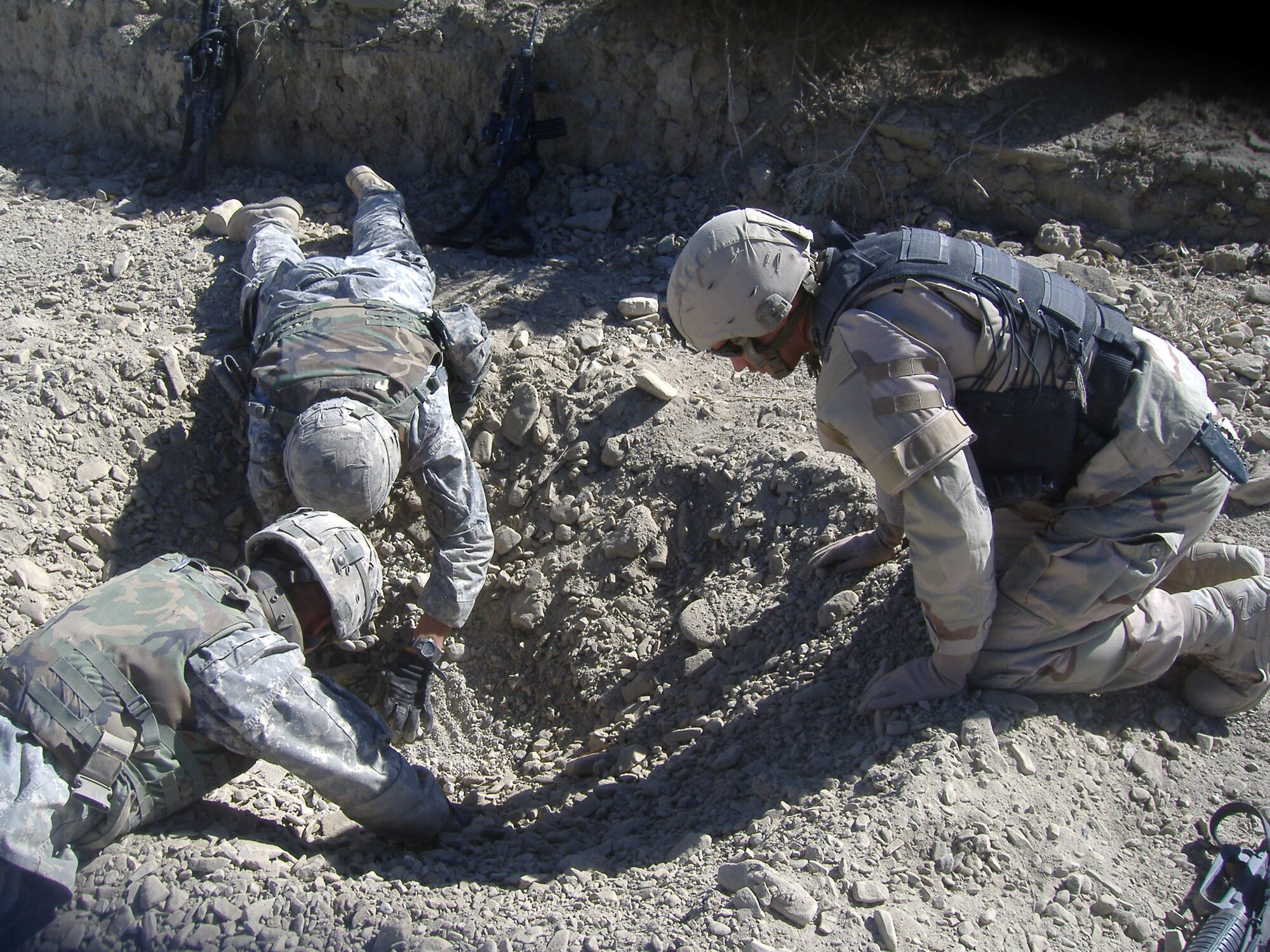 Staff Sgt. Matthew Nuckolls and some Soldiers he was working with examine a crater in Afghanistan for forensic evidence. Sergeant Nuckolls is one of eight members of Peterson’s Explosive Ordinance Detachment who have recently deployed to Iraq and Afghanistan. (U.S. Air Force photo)