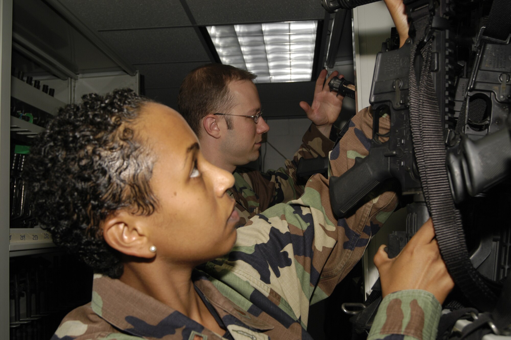 2nd Lt. Lidia Iyassu, 436th Security Forces Squadron logistics officer, and Senior Airman Nathan Foose, 512th Security Forces Squadron response force leader, conduct daily accountability checks and inventory of M-4 rifles.  Assigned weapons are inspected after every shift. (U.S. Air Force photo/Airman Shen-chia Chu)