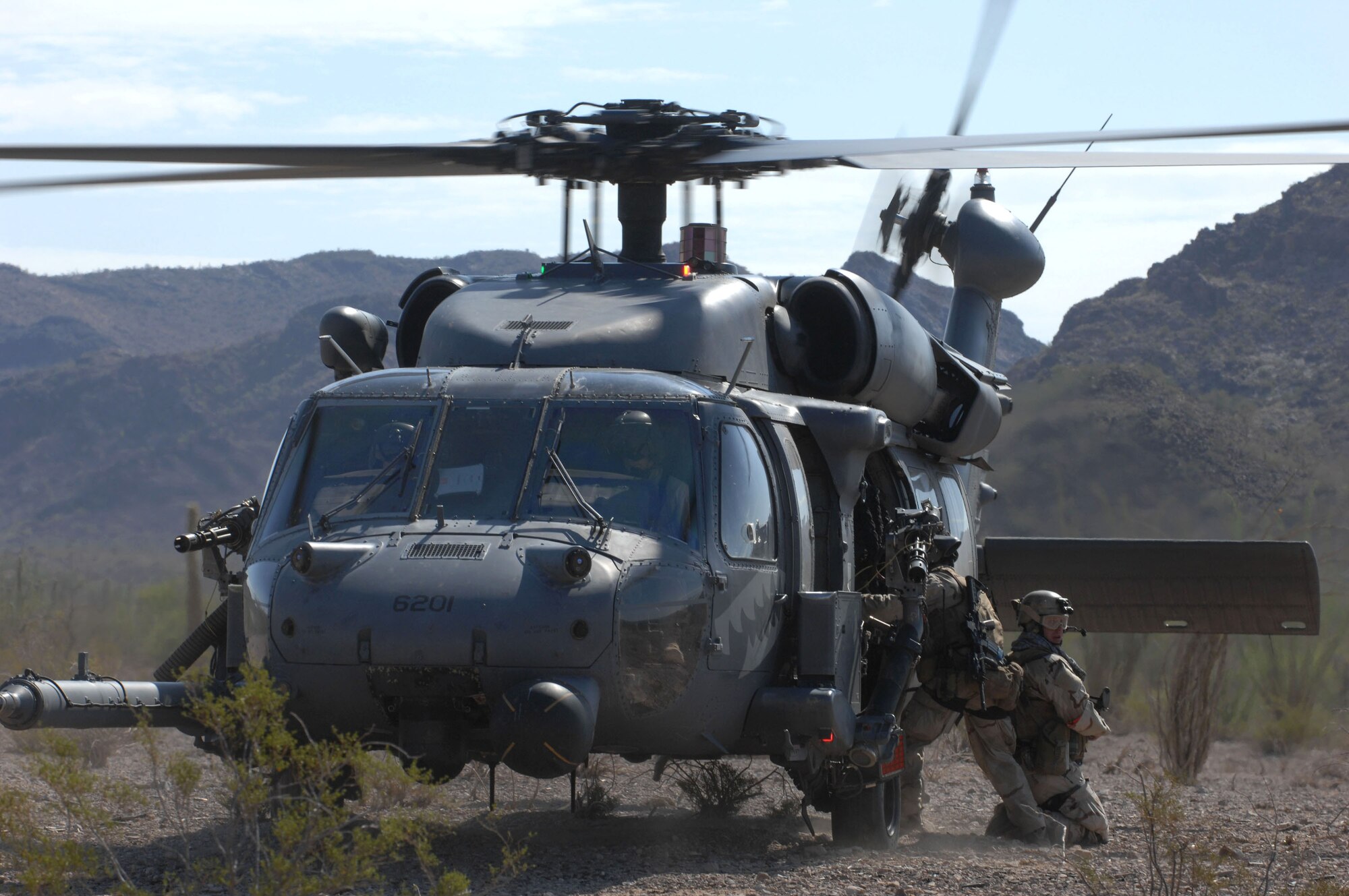 Staff Sgt. David Glass covers his teammate as he climbs on an 55th RQS HH-60 Pave Hawk during evacuation procedures during Exercise Angel Thunder July 16 at Gila Bend, Ariz. Sergeant Glass is a 48th Rescue Squadron pararesueman from Davis-Monthan Air Force Base, Ariz. The exercise is designed to provide realistic combat search and rescue training for Airmen in combat rescue forces. (U.S. Air Force photo/Staff Sgt. Lanie McNeal)
