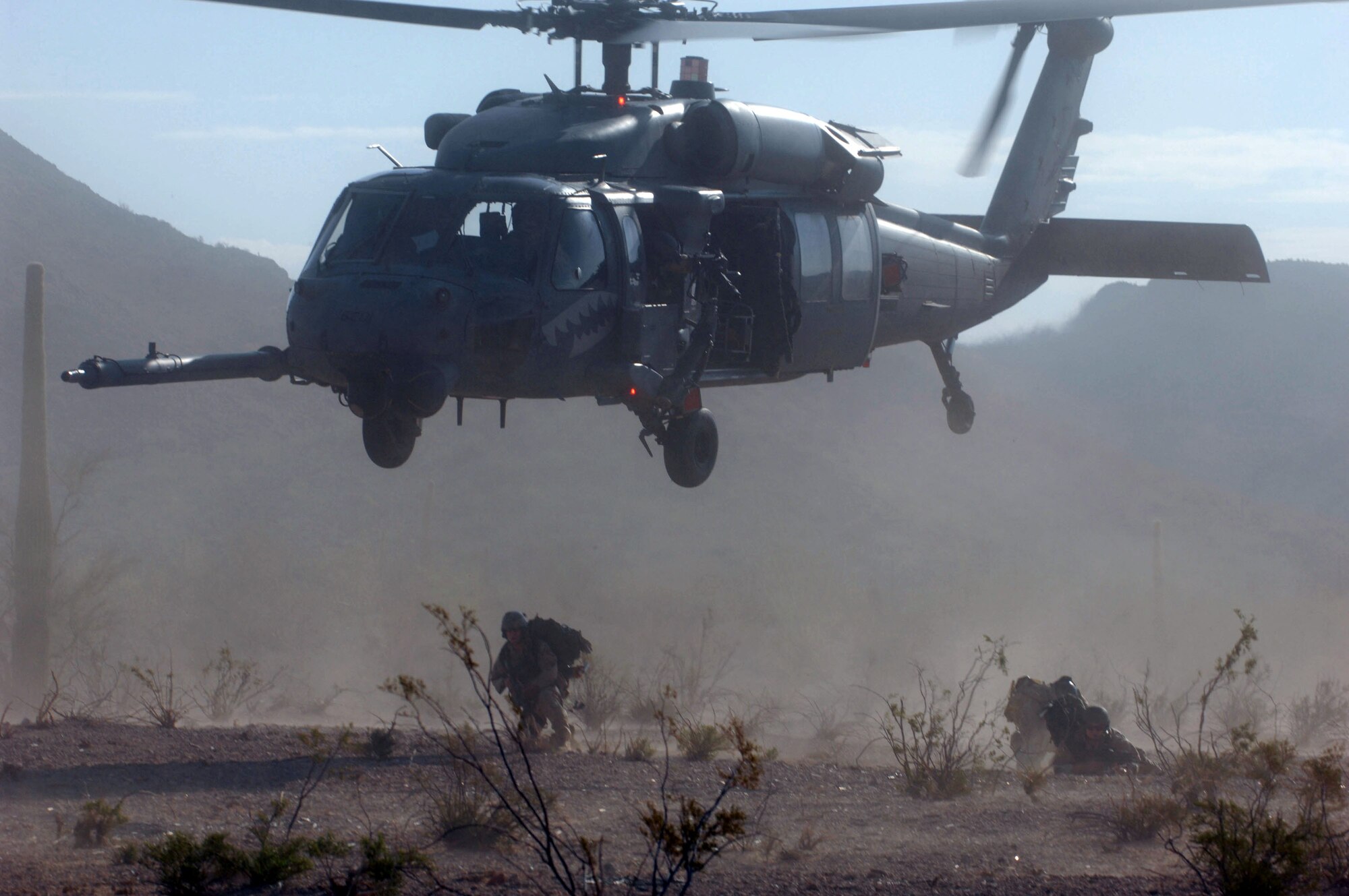 48th Rescue Squadron pararescueman secure the area on the ground after being inserted by a 55th Rescue Squadron HH-60 Pave Hawk during Exercise Angel Thunder July 16 at Gila Bend, Ariz. The exercise is designed to provide realistic combat search and rescue training for Airmen in combat rescue forces. Members of the 48th and 55th Rescue Squadrons are from Davis-Monthan Air Force Base, Ariz. (U.S. Air Force photo/Staff Sgt. Lanie McNeal) 
