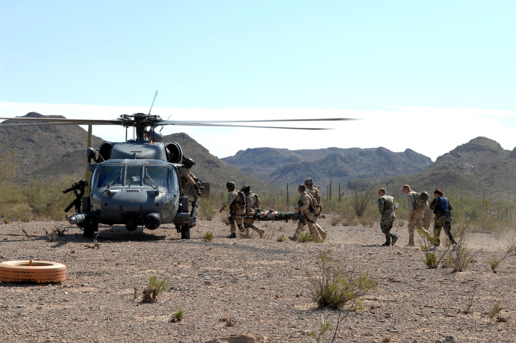 48th Rescue Squadron pararescuemen transport rescuees to an awaiting HH-60 Pave Hawk from the 55th RQS during Exercise Angel Thunder July 16 at Gila Bend, Ariz. The exercise is designed to provide realistic combat search and rescue training for Airmen in combat rescue forces. Members of the 48th and 55th Rescue Squadrons are from Davis-Monthan Air Force Base, Ariz. (U.S. Air Force photo/Staff Sgt. Lanie McNeal) 
