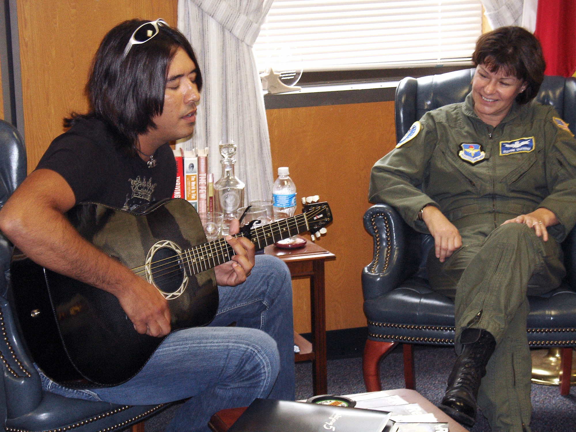 Up-and-coming country music singer, Donovan Chapman, performs for Brig. Gen. Suzanne Vautrinot and her immediate staff during a short visit to Air Force Recruiting Service to create two radio public service announcements supporting retention and recruiting goals. (US Air Force photo/Chet DelSignore)
