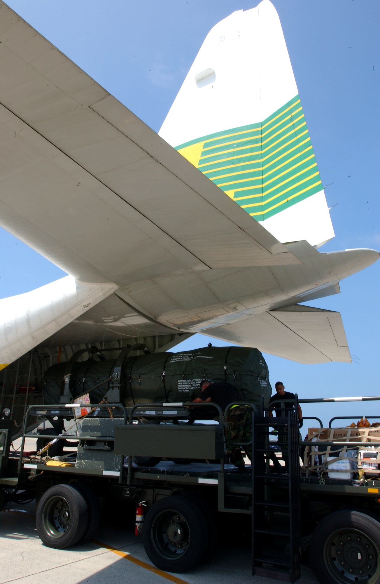 Staff Sgt. Alejandro Castillo and Staff Sgt. James Cantu, 733rd Air Mobility Squadron, load heavy cargo equipment onto an L-100 civilian aircraft at Kadena Air Base, Japan, July 19. The plane travels to Osan AB, Korea; Yokota AB, Misawa AB and Kadena three times a week delivering and dropping off equipment.
U.S. Air Force photo Staff Sgt. Reynaldo Ramon

