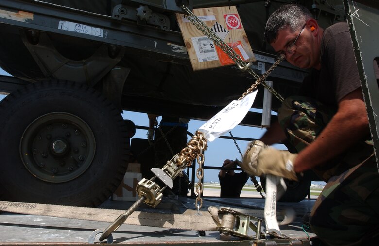 Staff Sgt. James Cantu, 733rd Air Mobility Squadron, ties down some boxes on a pallet before pushing a heavy piece of cargo onto an L-100 civilian aircraft at Kadena Air Base, Japan, July 19. The  aircraft travels to Osan AB, Korea; Yokota AB, Misawa AB and Kadena three times a week delivering and picking up equipment.
U.S. Air Force photo/Staff Sgt. Reynaldo Ramon