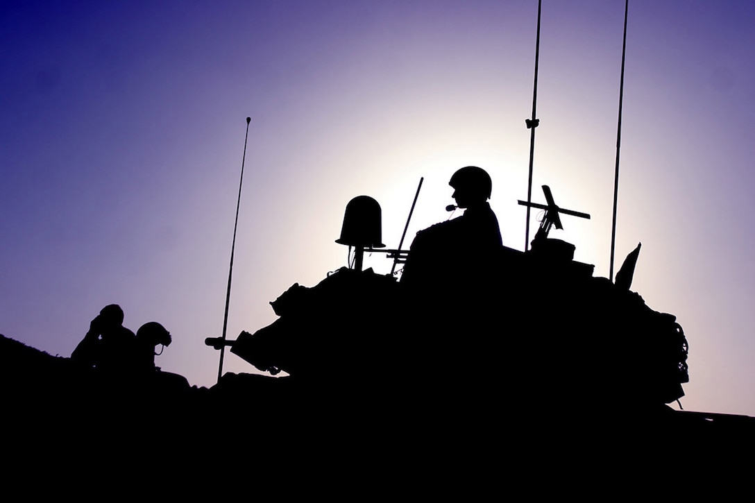 COMBAT OUTPOST RAWAH, IRAQ, (JULY 24, 2007) – A Marine with Company C, 1st Light Armored Reconnaissance Battalion, Regimental Combat Team 2, stands guard in the turret of a light armored vehicle as the day comes to a close during ‘Operation Mawtini.’ The battalion is part of the regimental-wide operation which kicked off July 15, 2007. Official Marine Corps Photo By Cpl. Ryan C. Heiser.