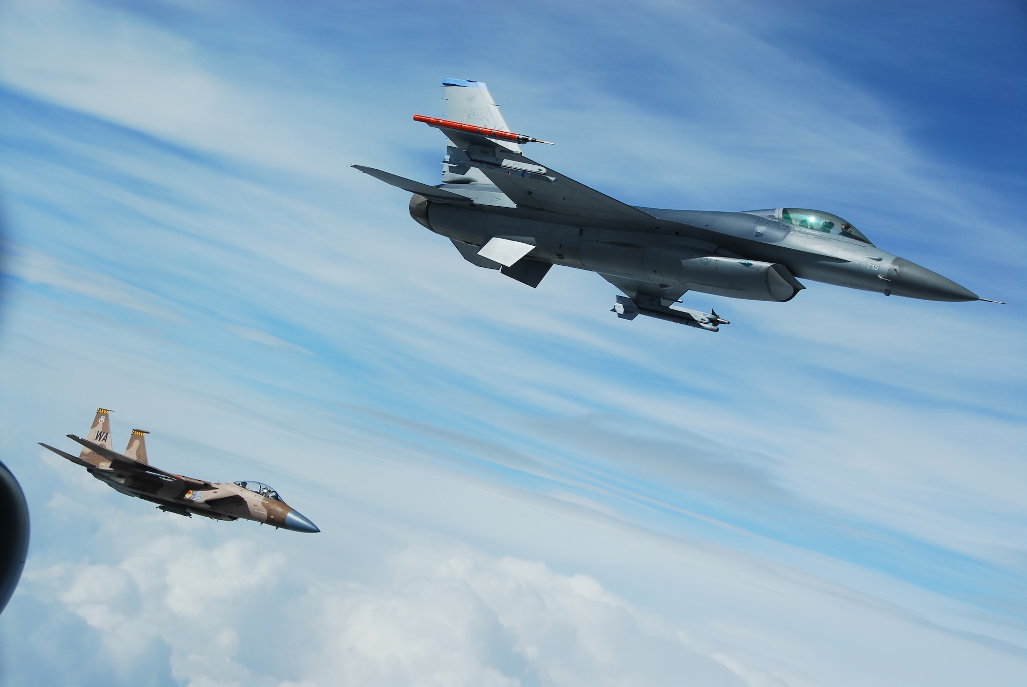 EIELSON AIR FORCE BASE, Alaska -- An F-16, 18th Fighter Squadron, Eielson AFB, and F-15C, 65th Aggressor Squadron, Nellis AFB, are both working together playing the hostile forces role over the Pacific Alaskan Range Complex on July 19 during Red Flag-Alaska 07-3. The PARC provides 67,000 square miles of airspace, one conventional bombing range and two tactical bombing ranges containing more than 400 different types of targets and more than 30 threat simulators, both manned and unmanned. (U.S. Air Force Photo by Airman 1st Class Jonathan Snyder)