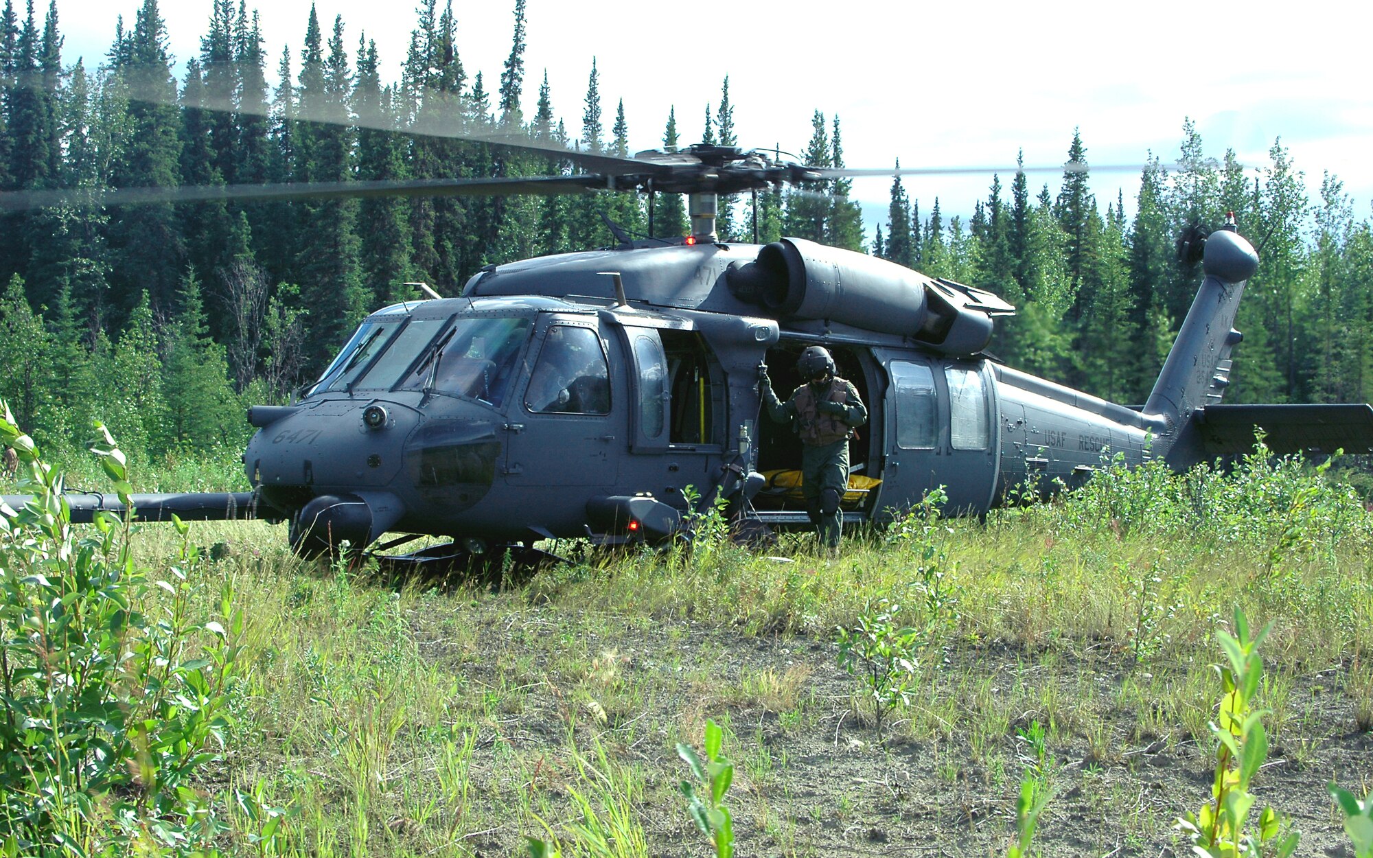 EIELSON AIR FORCE BASE, Alaska -- Staff Sgt. Corey Erconlani, 210th Rescue Squadron, exits an HH-60 Pave Hawk in the midst of a combat-search-and-rescue training scenario at Red Flag-Alaska. Red Flag-Alaska is a multinational air combat training exercise held in the Pacific Alaska Range Complex. (U.S. Air Force photo by Staff Sgt. Shawn J. Jones)