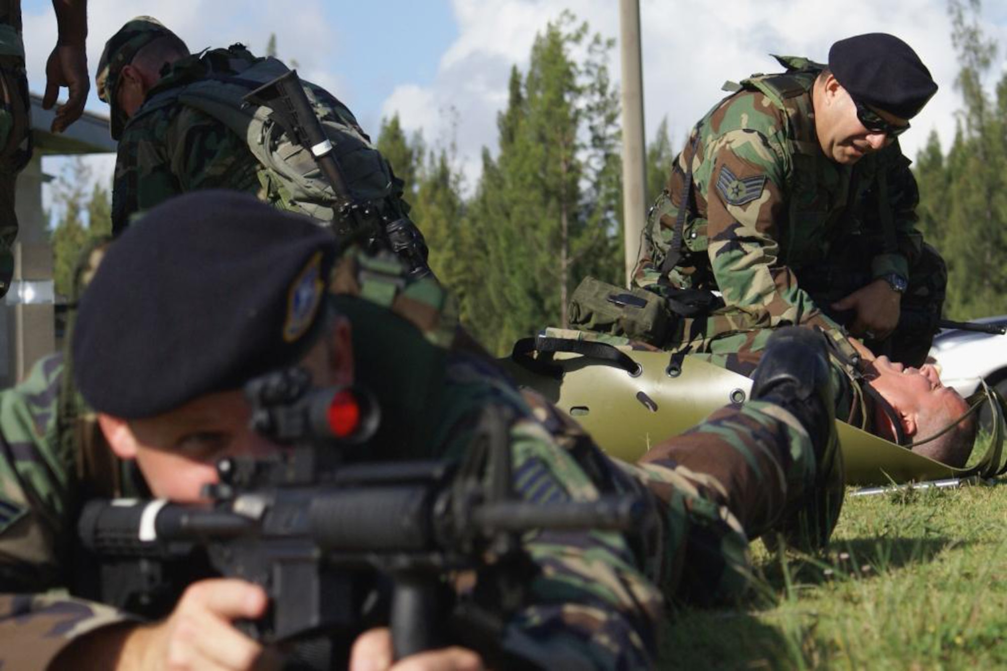 Staff Sgt. John Enser provides cover as Staff Sgt. Ranier Gonzalez (right) cares for a “wounded” troop during training here July 18. Airmen from the 482nd Security Forces and Medical Squadrons joined members of Special Operations Command South for critical training in the Combat Lifesaver Course. Participants learned advanced first-aid techniques and how to stabilize wounded troops before evacuating them. (U.S. Air Force photo/Dan Galindo)