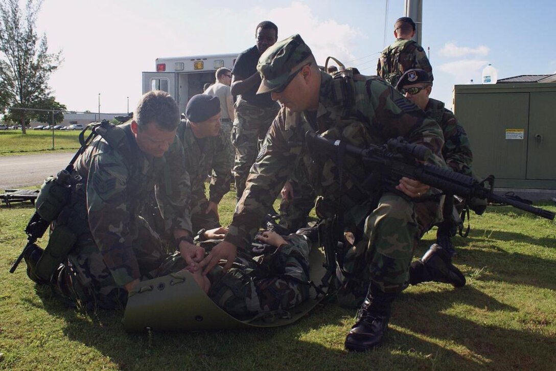 Master Sgt. John Frank and Staff Sgt. John Enser practice checking for airway obstructions on Senior Airman Frank Betancourt here July 18. Airmen from the 482nd Security Forces and Medical Squadrons joined members of Special Operations Command South for critical training in the Combat Lifesaver Course. Participants learned advanced first-aid techniques and how to stabilize wounded troops before evacuating them. (U.S. Air Force photo/Dan Galindo)