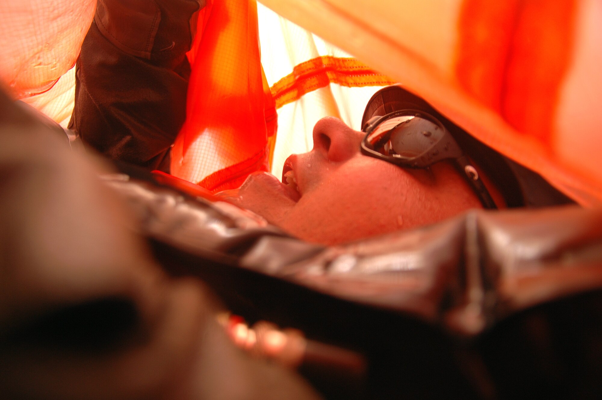 EGLIN AIR FORCE BASE, Fla. -- Garrett McNeil, honorary commander for the 33d Fighter Wing's 60th Fighter Squadron, makes his way underneath a parachute canopy July 20 to escape to daylight. The simulation was part of Survivor Skills Day, during which honorary commanders learned land and water survival tactics wing pilots are trained to use in emergency situations. Honorary commanders are civic leaders paired with wing leadership for a year-long immersion in the mission, with a goal of educating the civilians about the Air Force and its people. Honorary commanders from the 53d Wing also participated. (U.S. Air Force photo by Staff Sgt. Bryan Franks)

