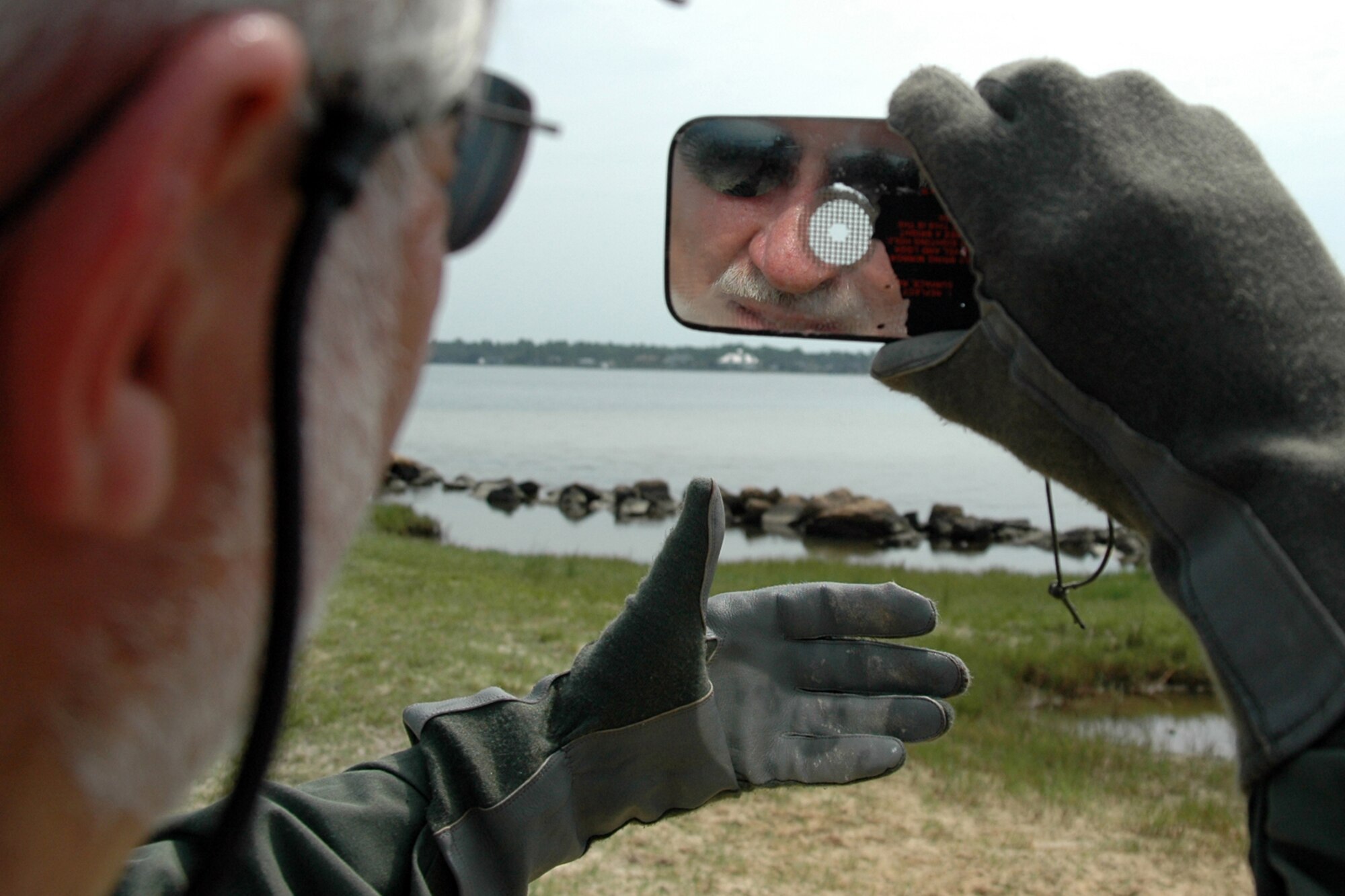 EGLIN AIR FORCE BASE, Fla. -- Peter Bos, honorary commander for the 53d Wing's 29th Test and Evaluation Squadron, spots himself in a signal mirror July 20 during Survival Skills Day on Eglin Air Force Base. The event was held by the 33d Fighter Wing and the 53d Wing to teach their honorary commanders land and water survival tactics wing pilots are trained to use in emergency situations. Honorary commanders are civic leaders paired with wing leadership for a year-long immersion in the mission, with a goal of educating the civilians about the Air Force and its people. (U.S. Air Force photo by Staff Sgt. Bryan Franks)

