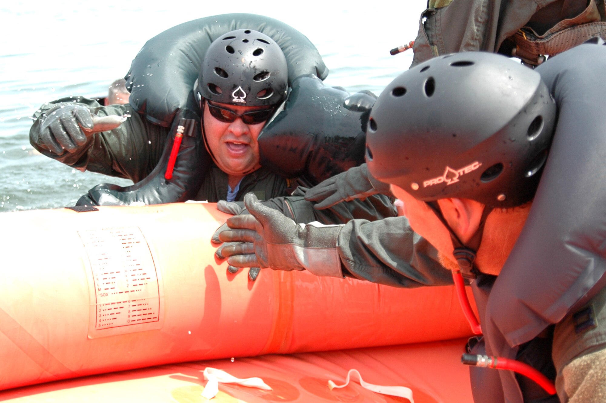 EGLIN AIR FORCE BASE, Fla. -- Steve Horton offers Garrett McNeil a hand to climb aboard a life raft July 20 during Survivor Skills Day on Eglin Air Force Base. The event was hosted by the 33d Fighter Wing and the 53d Wing to teach their honorary commanders land and water survival tactics wing pilots are trained to use in emergency situations. Honorary commanders are civic leaders paired with wing leadership for a year-long immersion in the mission, with a goal of educating the civilians about the Air Force and its people. (U.S. Air Force photo by Staff Sgt. Bryan Franks)
