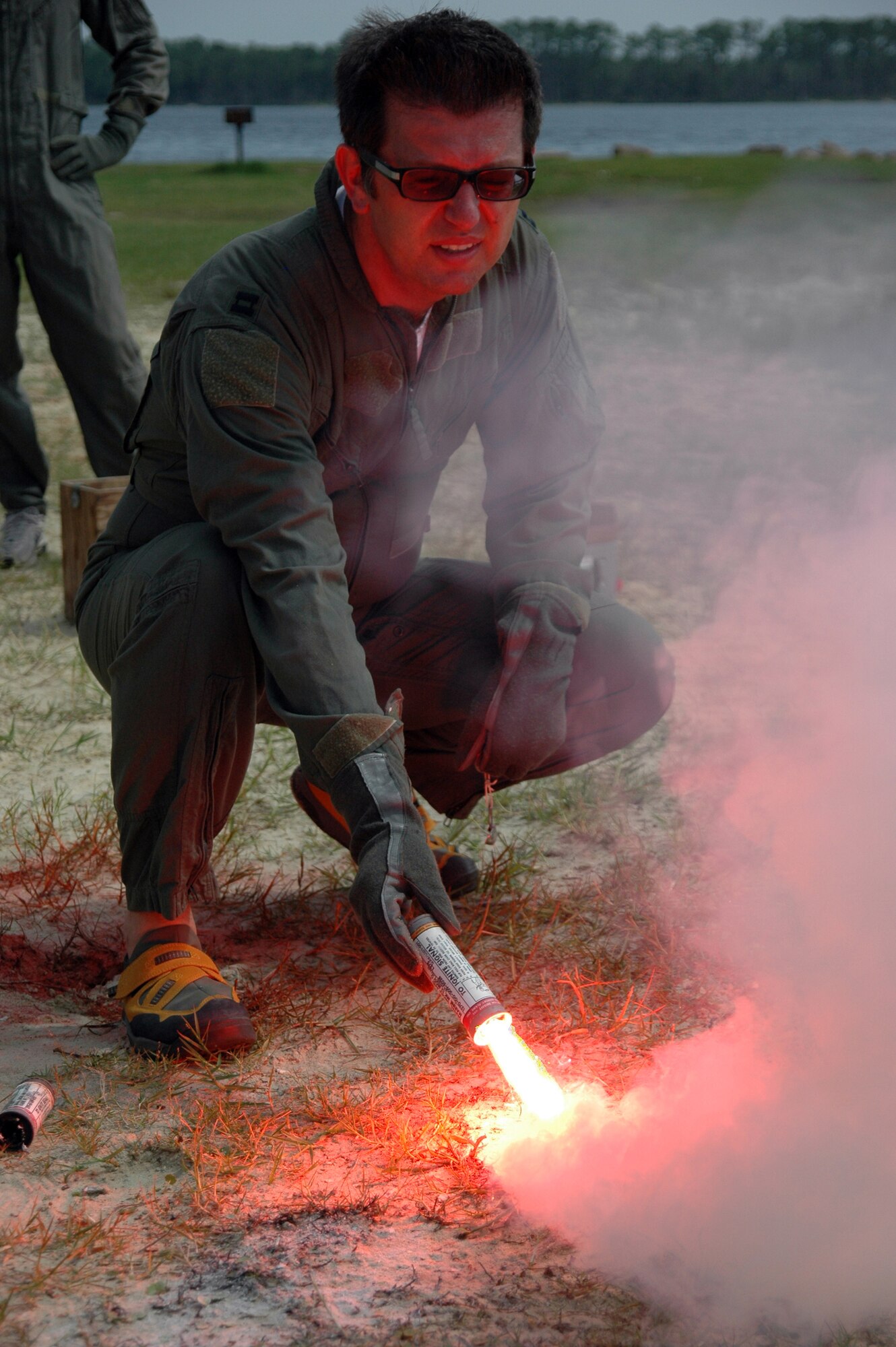 EGLIN AIR FORCE BASE, Fla. -- A flare ignites in the hand of Rob Babcock, honorary commander for the 33d Fighter Wing's 33d Aircraft Maintenance Squadron, July 20. Mr. Babcock was participating in Survivor Skills Day, during which honorary commanders learned land and water survival tactics wing pilots are trained to use in emergency situations. Honorary commanders are civic leaders paired with wing leadership for a year-long immersion in the mission, with a goal of educating the civilians about the Air Force and its people. Honorary commanders from the 53d Wing also participated. (U.S. Air Force photo by Staff Sgt. Bryan Franks)
