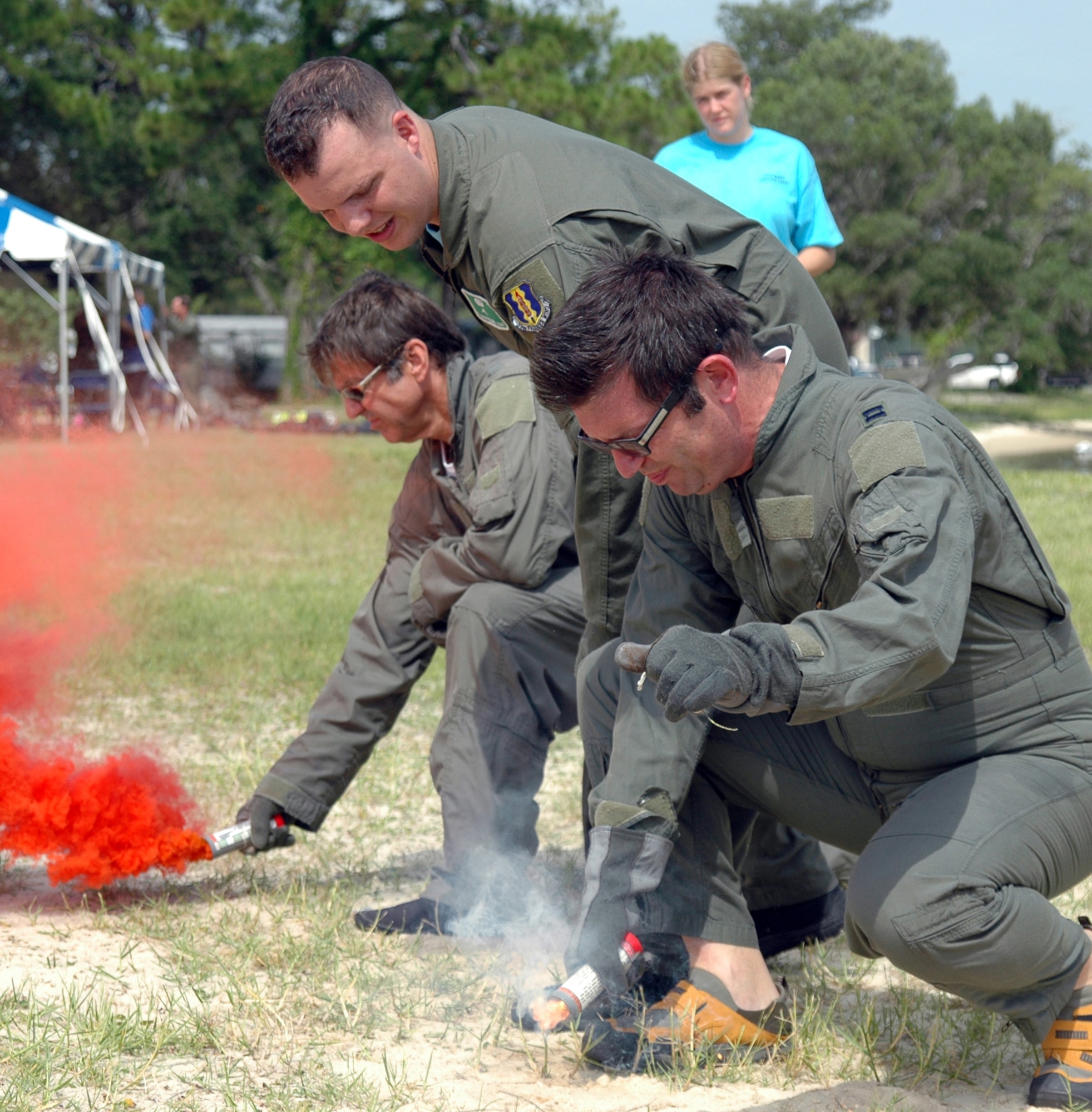 EGLIN AIR FORCE BASE, Fla. -- Robert Babcock and Richard McNeese, Honorary Commanders for the 33d Fighter Wing's 33d Aircraft Maintenance Squadron and 33d Operations Support Squadron ignite flares under the watchful eye of Staff Sgt. Benjamin Rosciglione, 33d Operation Support Squadron Survival, Evasions, Resist and Escape instructor. The event taught honorary commanders land and water survival tactics wing pilots are trained to use in emergency situations. Honorary commanders are civic leaders paired with wing leadership for a year-long immersion in the mission, with a goal of educating the civilians about the Air Force and its people. Honorary commanders from the 53d Wing also participated. (U.S. Air Force photo by Staff Sgt. Bryan Franks)
