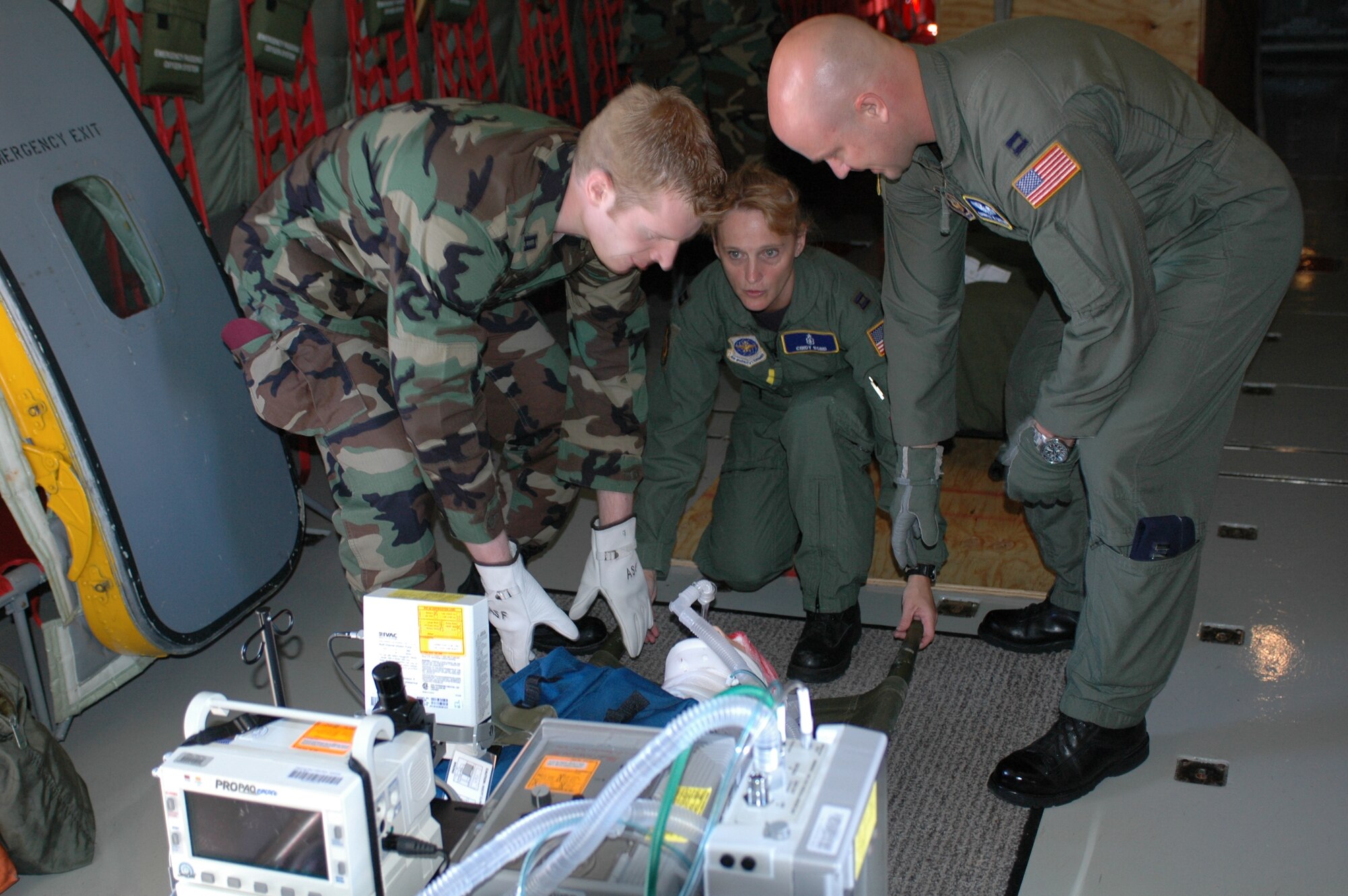 Members of the Critical Care Air Transport Team prepare to secure a standard mannequin after the “patient” was loaded onto a KC-135 Stratotanker July 13. Members of the Critical Care Air Transport Team used the flight to get extra training with the transport of critical care patients. (U.S. Air Force photo/Airman 1st Class Kristen Rohrer)