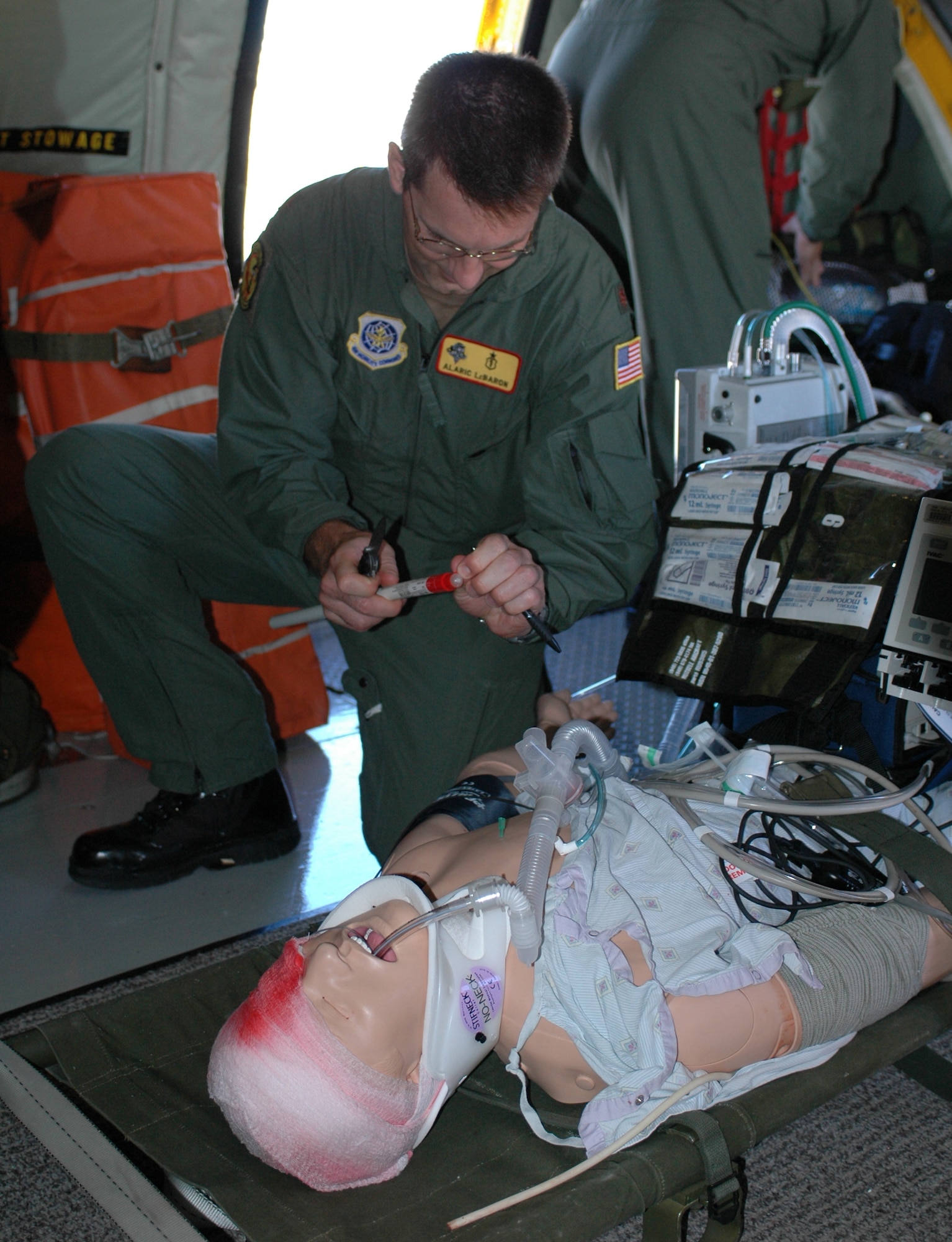 Maj. (Dr.) Alaric LeBaron, 60th Medical Surgical Operations Squadron, prepares to insert a chest tube into a standard mannequin “patient” during a practice flight July 13. Members of the Critical Care Air Transport Team used the flight to get extra training with the transport of critical care patients. (U.S. Air Force photo/Airman 1st Class Kristen Rohrer)