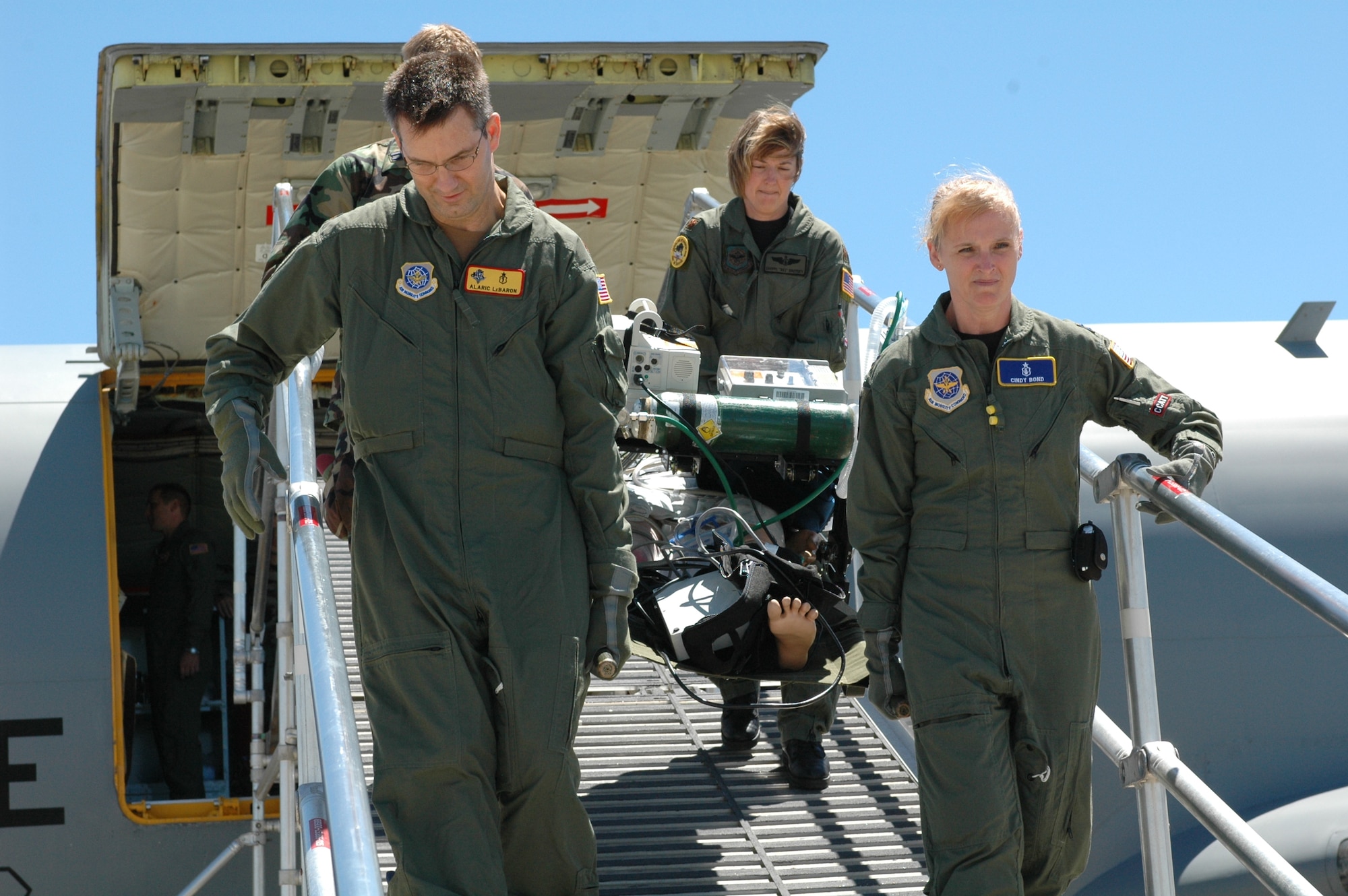 Maj. (Dr.) Alaric LeBaron, 60th Medical Surgical Operations Squadron, and Capt. Cindy Bond, 60th Inpatient Squadron critical care nurse, assist in unloading a Standard Mannequin “patient” from a KC-135 Stratotanker July 13. Members of the Critical Care Air Transport Team participated in the practice flight to get extra practice transporting critical care patients. (U.S. Air Force photo/Airman 1st Class Kristen Rohrer)