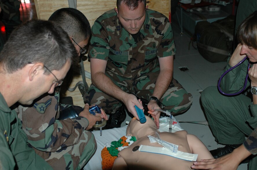 Members of the 60th Medical Group prepare to intubate a standard mannequin during a practice flight July 13. The standard mannequin is used to train medical residents and members of the Critical Care Air Transport Team. (U.S. Air Force photo/Airman 1st Class Kristen Rohrer)