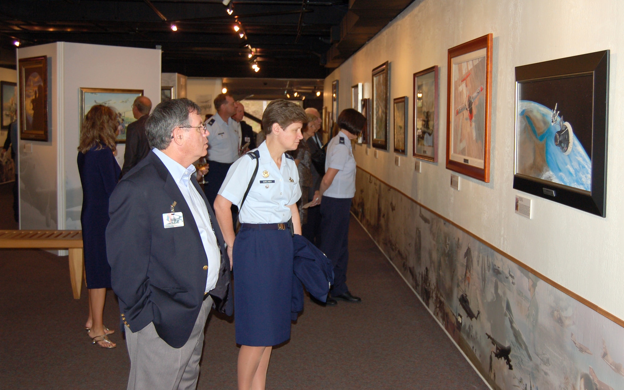 Local military and civil leaders look at an exhibit titled "Heritage to Horizons: U.S. Air Force History Through Art," which contains more than 50 art pieces from the Air Force Art Program and is on display at the University of Texas at San Antonio's Institute of Texan Cultures through Aug. 12. (U.S. Air Force photo/Staff Sgt. Shad Eidson) 
